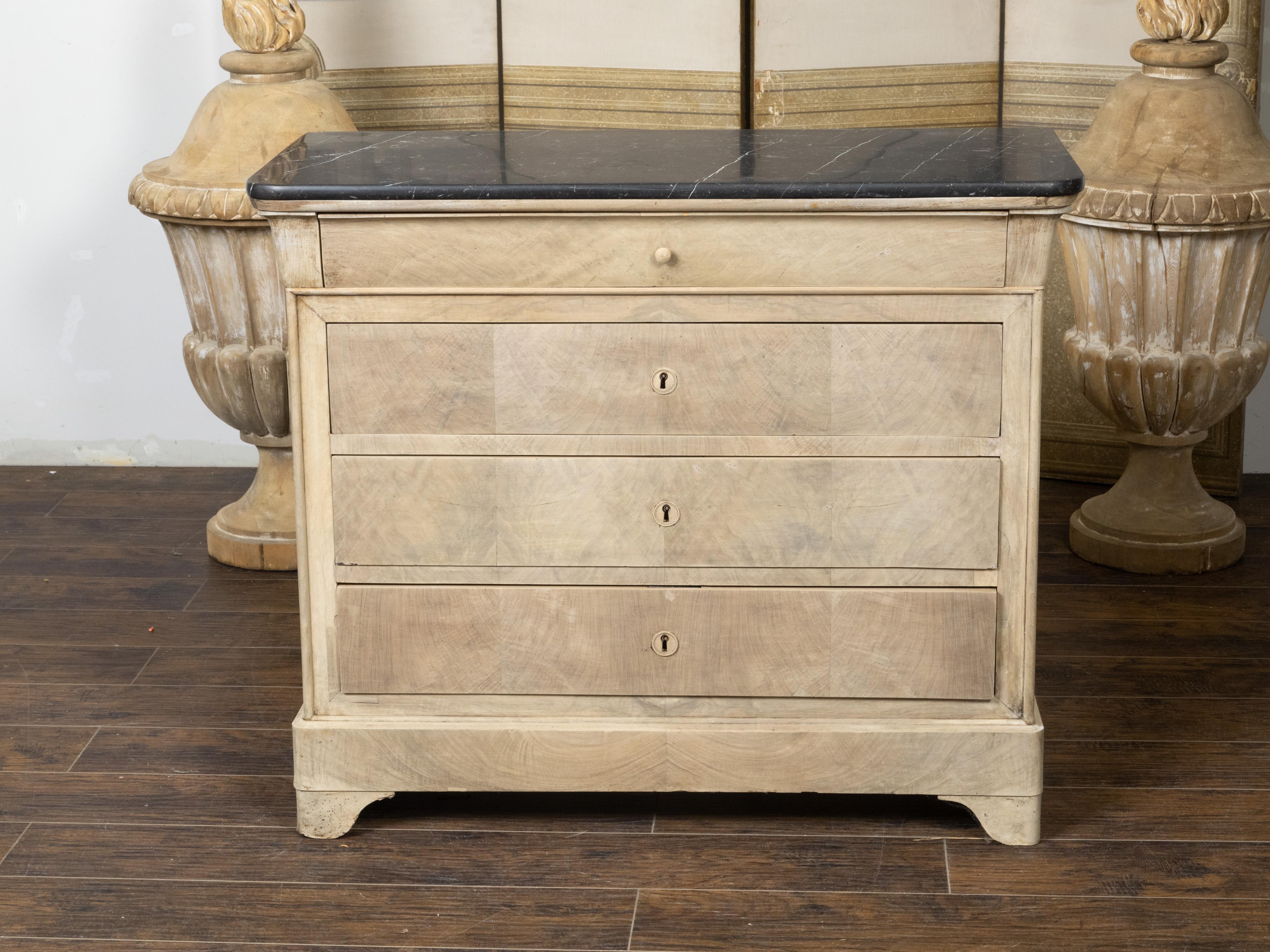 A French Louis-Philippe bleached walnut commode from the 19th century, with black marble top and four drawers. Created in France during the 19th century, this bleached walnut commode features a rectangular black and white veined marble top with