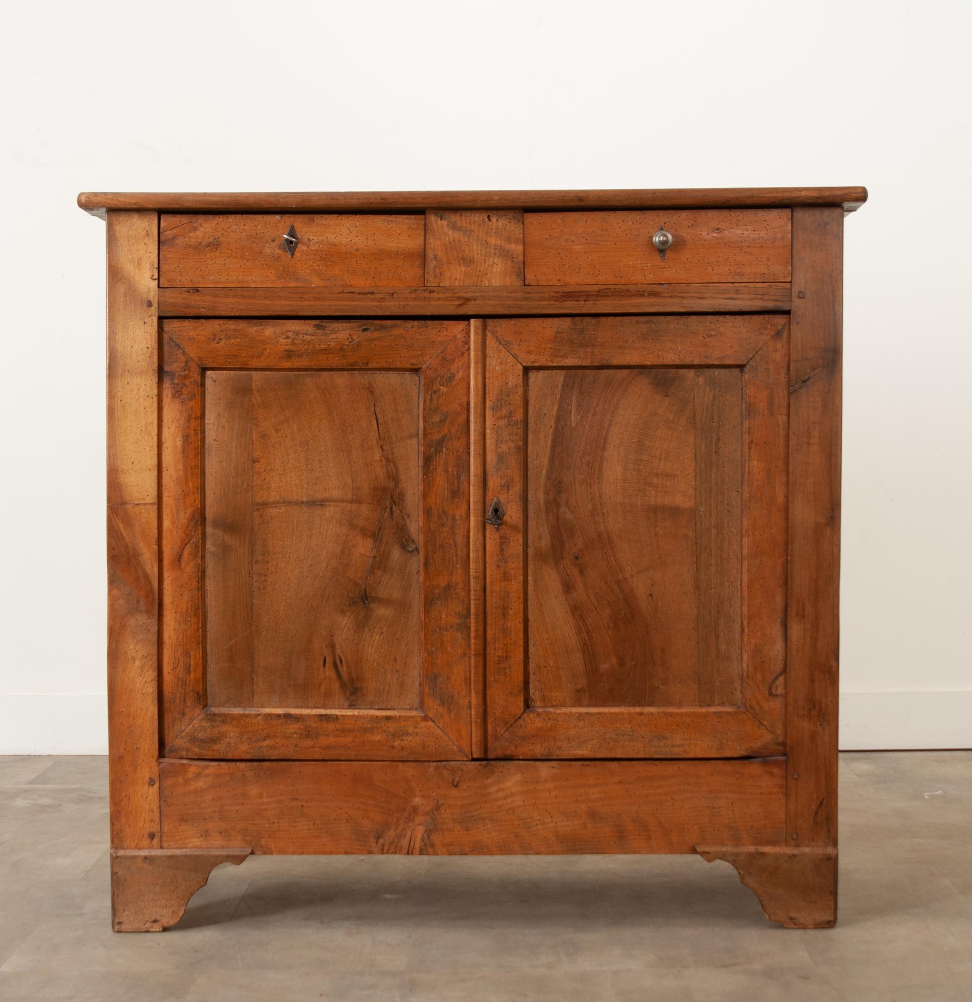 A delightful, tall French Louis Philippe buffet composed of solid walnut, pine and oak. This lightly toned buffet is designed with clean, straight lines, making this - and all Louis Philippe style pieces - extraordinarily versatile. The buffet has