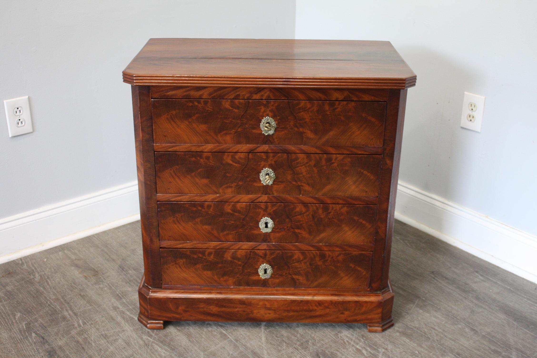 This Commode is made of marquetry of flamed mahogany. It has a small scale and is easy to place anywhere.
