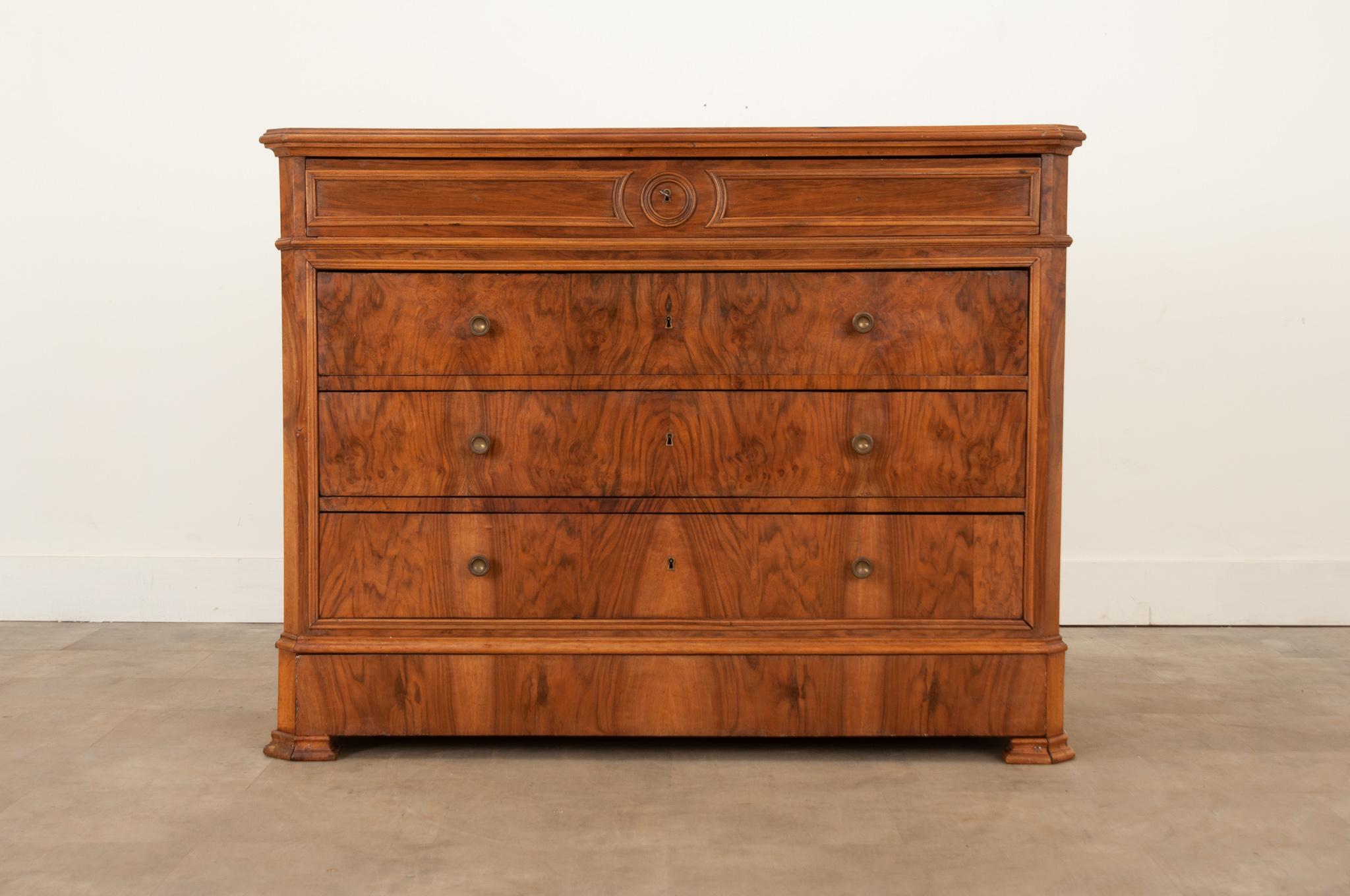 A truly stunning Louis Philippe style mahogany commode walnut crafted in France circa 1870. Five bookmatched drawers provide plenty of storage space. The top surface showcases the wood grain perfectly. The top drawer is beautifully paneled while the