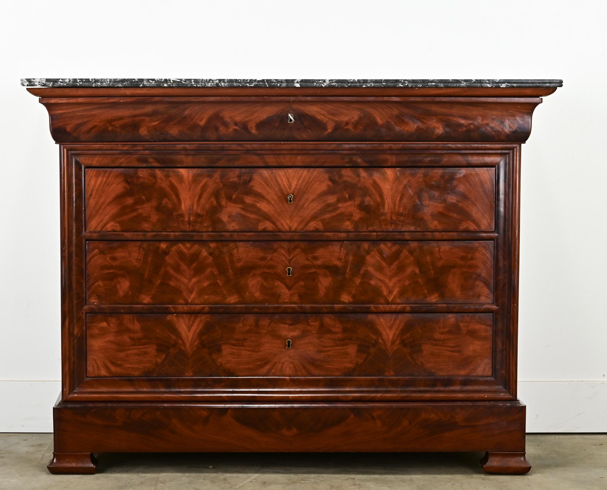 A handsome French 19th century Louis Philippe commode. The commode’s top is a Saint Anne marble with curved front edges making for a durable and attractive surface. The top drawer is hidden, just under the marble, and is free of hardware with a