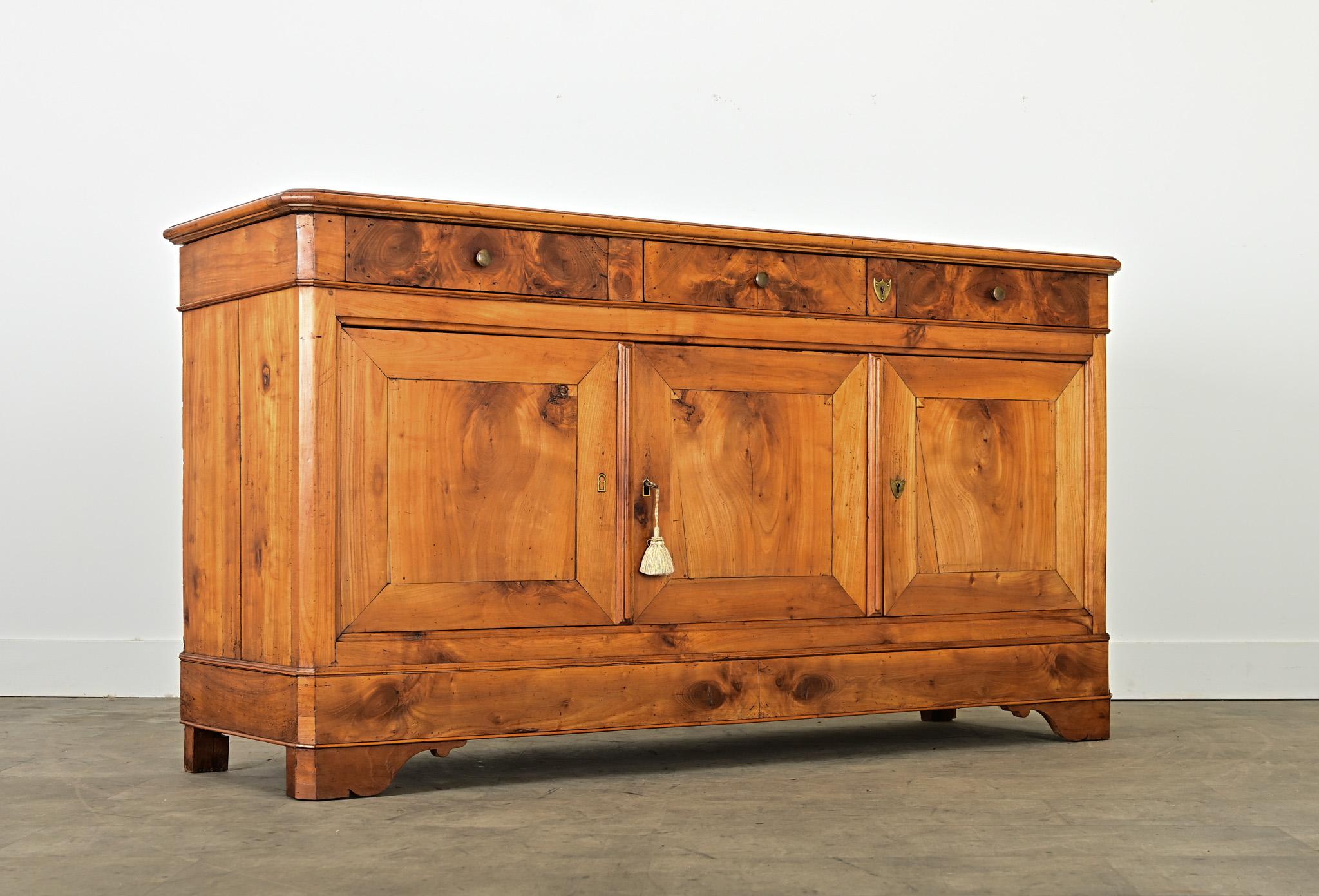 An engaging 19th Century Louis Philippe style fruitwood enfilade with a variety of figural grain patterns and luminous wood tones across the case. The top planks have a soft texture that complements the honey-gold color, bearing the evidence of two