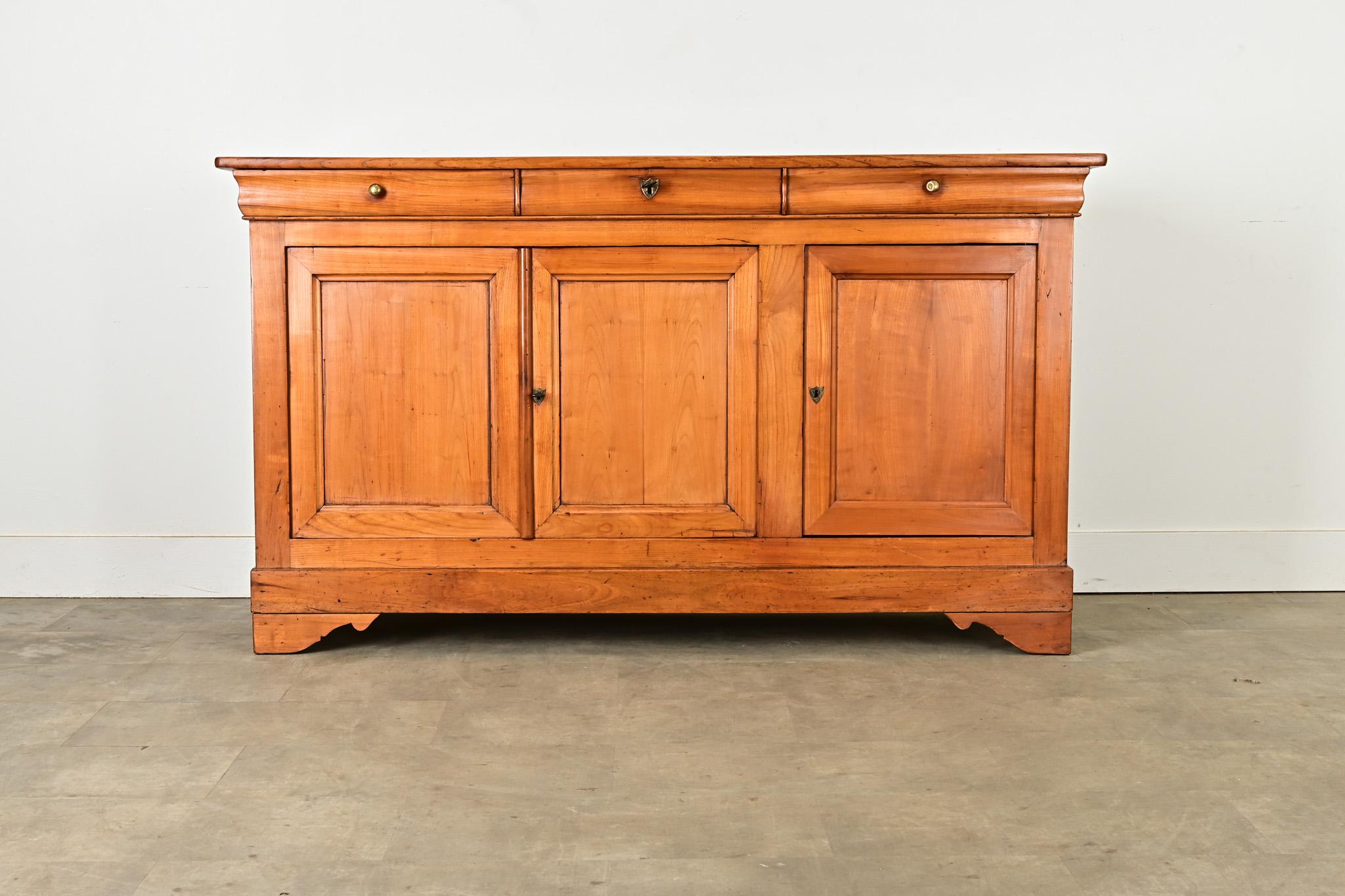 Questa bellissima enfilade in legno di Louis Philippe, risalente al 1840 circa, si distingue per i toni luminosi del legno e le venature che caratterizzano qualsiasi ambiente. Le due tavole superiori sono rifinite con una texture morbida e un bordo