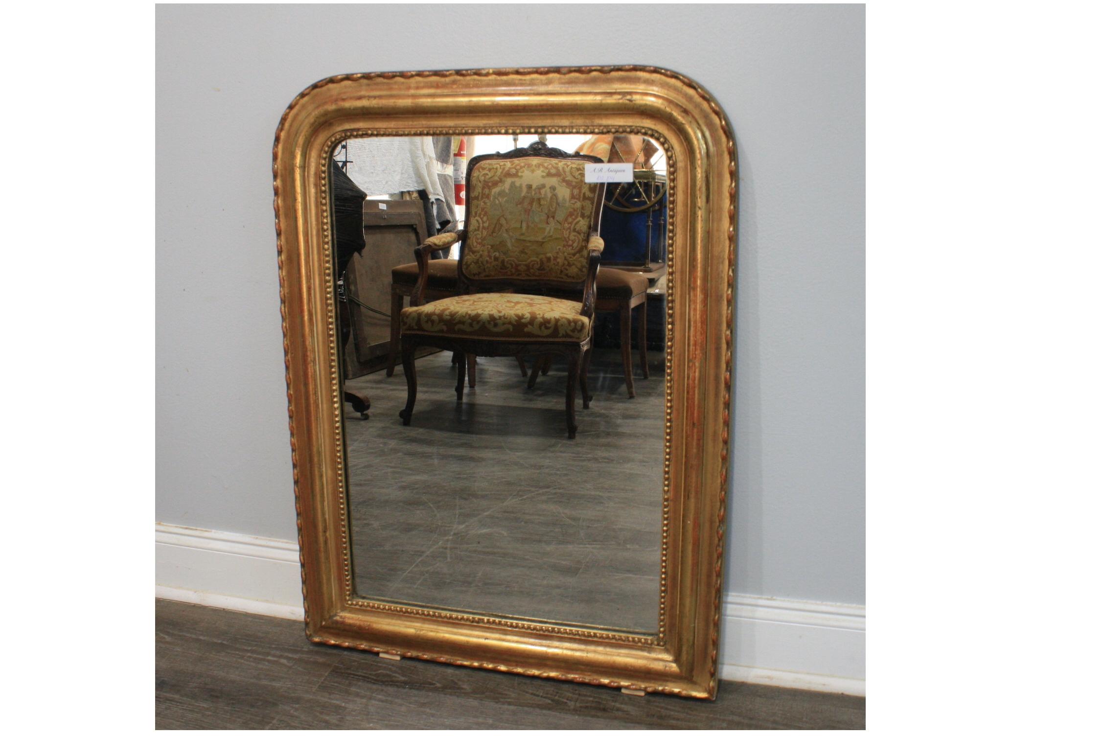 This 19th century French Louis-Philippe Mirror is covered of gold leaf and a serpentine pattern around it.