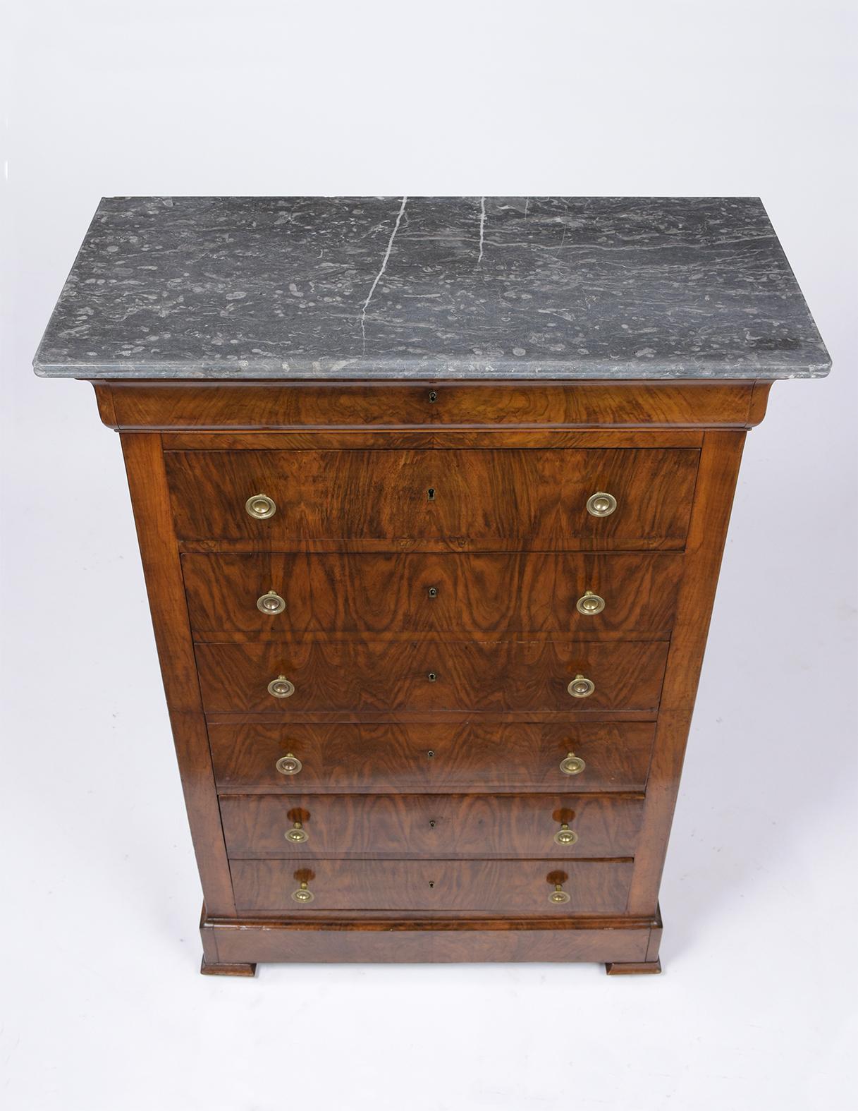 This French 19th Century Walnut Semaniere was handcrafted in the Louis Phillippe Style, has been completed restored, has its original grey color marble top, walnut finish, and has been waxed & polished developing a beautiful patina. The piece also