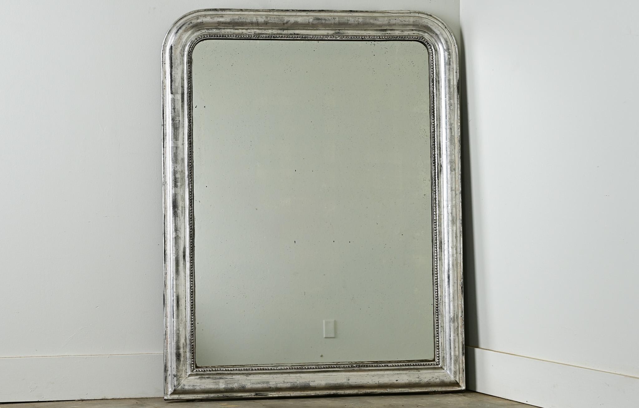 L'ossidazione tenue dell'argento dorato di questo specchio Louis Philippe crea interessanti texture tra i motivi a chiave greca intagliati nella cornice. Il foxing lentigginoso aggiunge un ulteriore livello di interesse al bel design. Guarda le