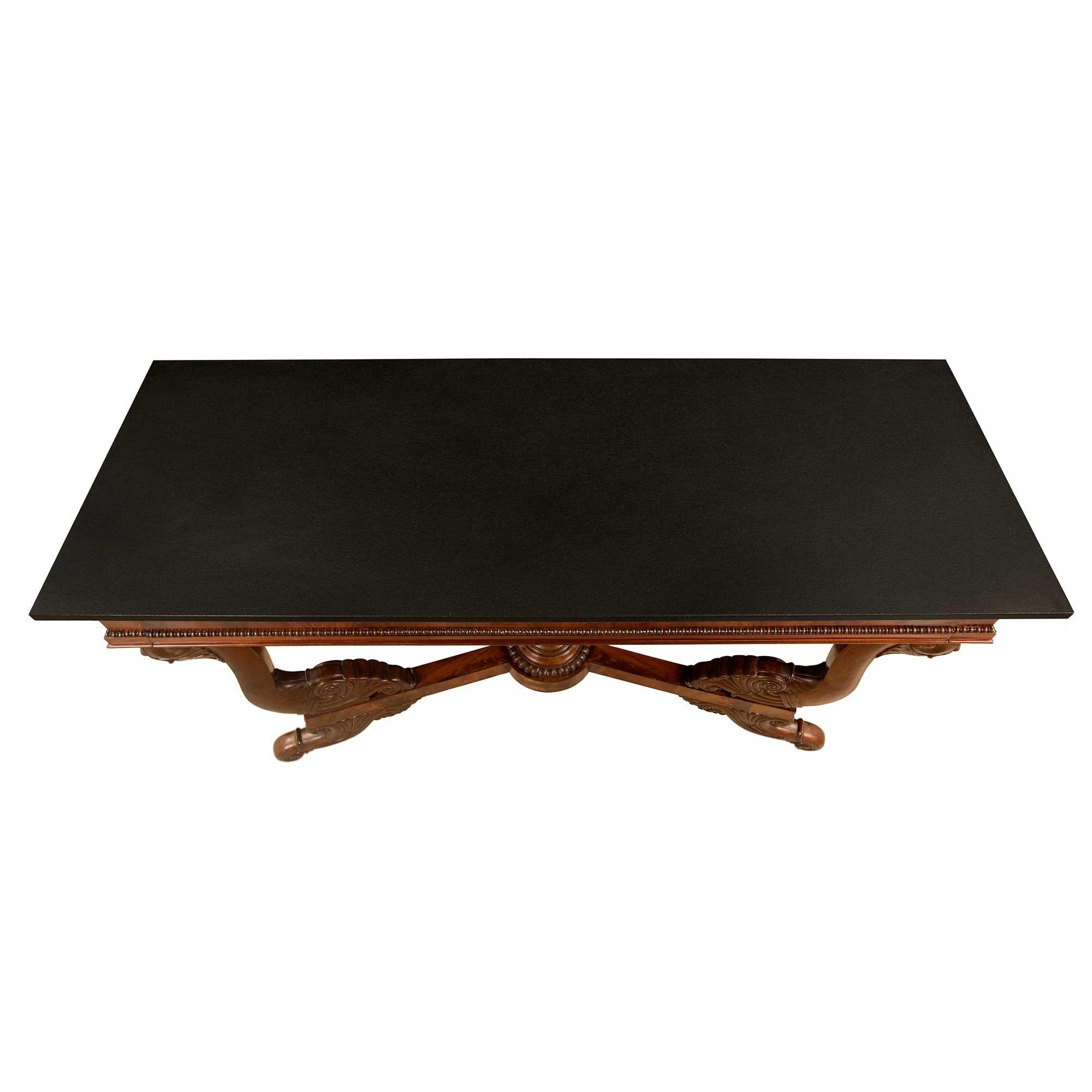 A very handsome French 19th century Louis Philippe st. flamed mahogany and black stone freestanding console. The console is raised by elegant scrolled supports with fine foliate designs. Each elegant scrolled leg displays richly carved foliate