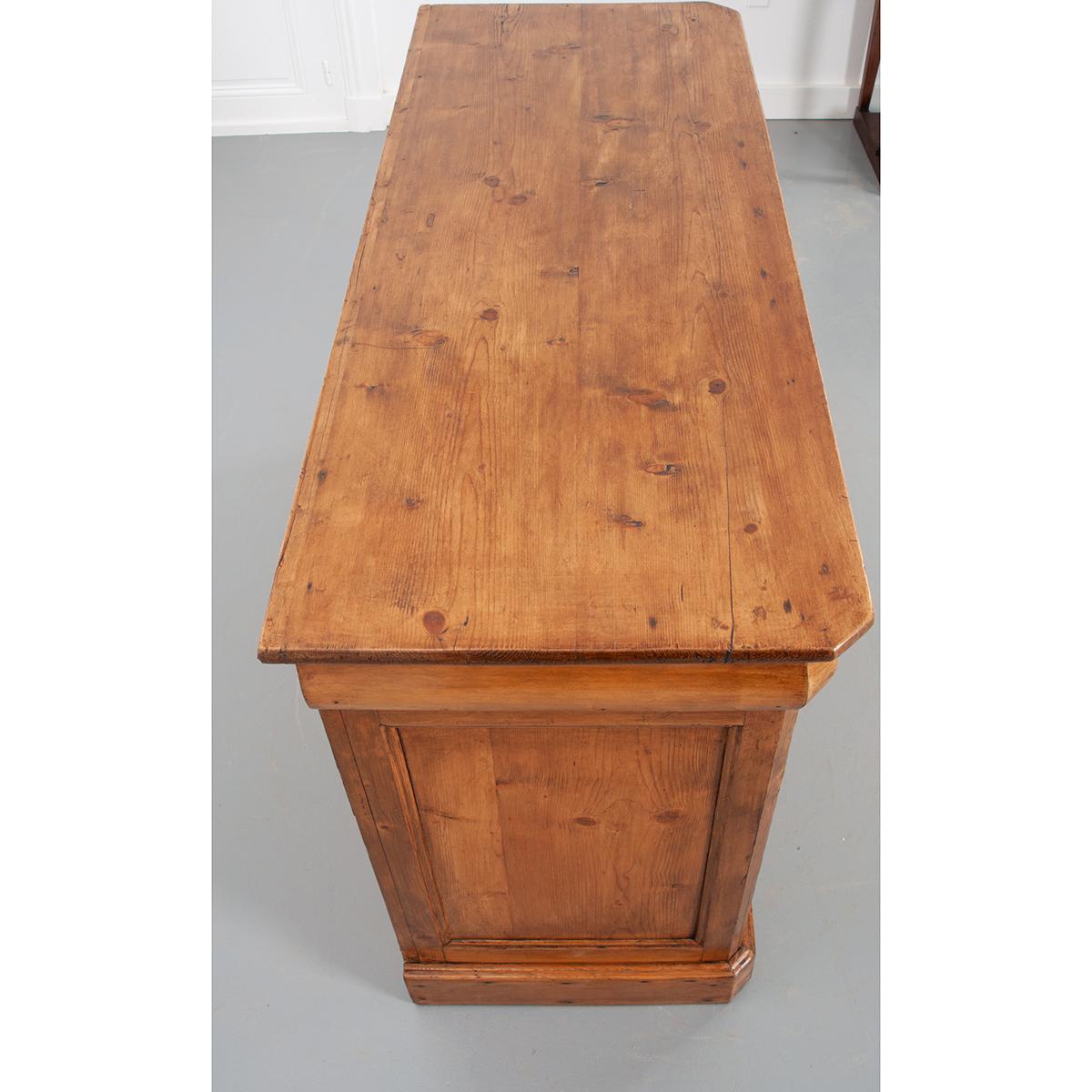 This nice Louis Philippe-style pine enfilade with canted corners, circa 1870, features a beautiful patinated finish highlighting the rustic charm of this piece. The wood top sits above an apron with three drawers, each with a turned wood knob. The