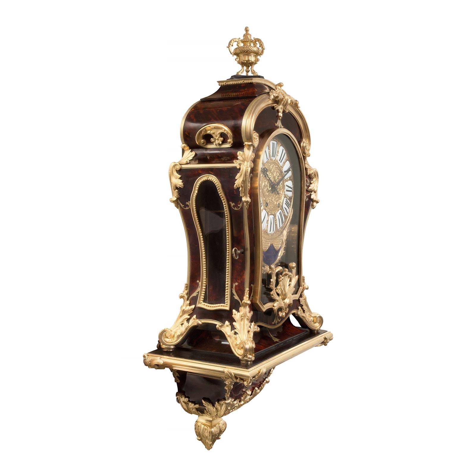 A stunning French 19th century Louis XIV st. tortoiseshell, brass and ormolu Cartel Clock signed F.Lesage Paris. The beautiful clock is raised on its original support shelf centered by a richly chased ormolu foliate final below a brass inlaid