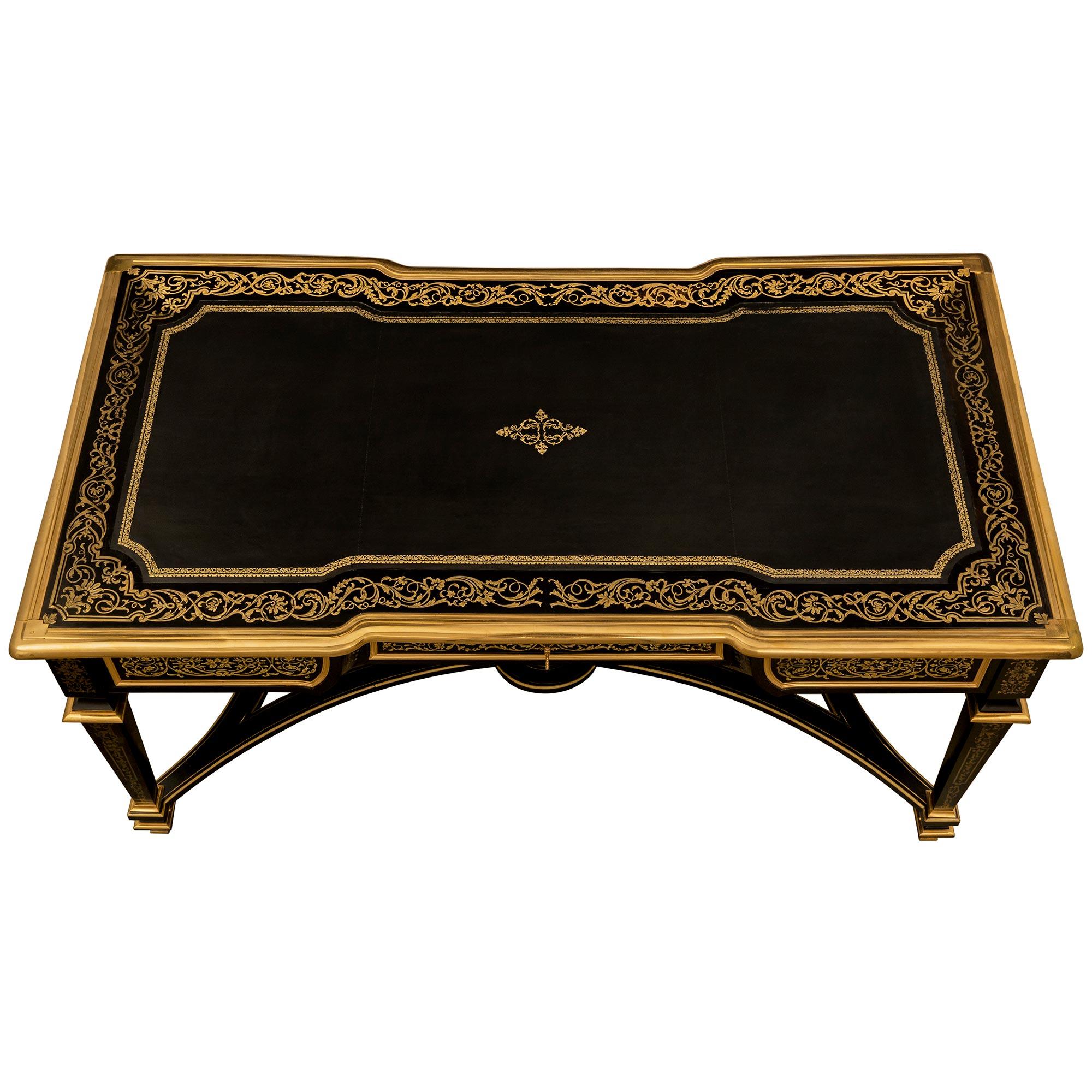 A handsome and richly detailed French 19th century Louis XIV st. Ebony, Brass and Ormolu Boulle desk. This wonderful rectangular desk is raised by four square tapered legs decorated by a mottled Ormolu band and bottom topie shaped feet. The legs are