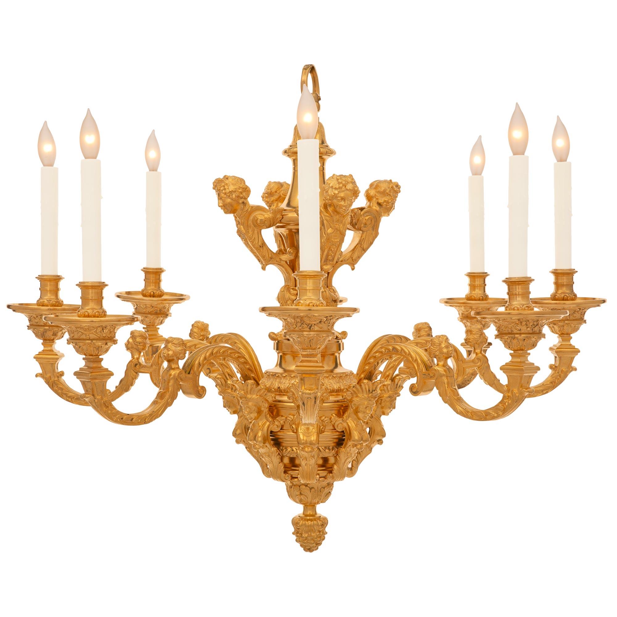 A handsome and very high quality French 19th century Louis XIV st. ormolu chandelier. The chandelier is centered by a fine bottom acorn finial below the mottled topie shaped body encased by finely detailed maidens. Each arm displays an elegant