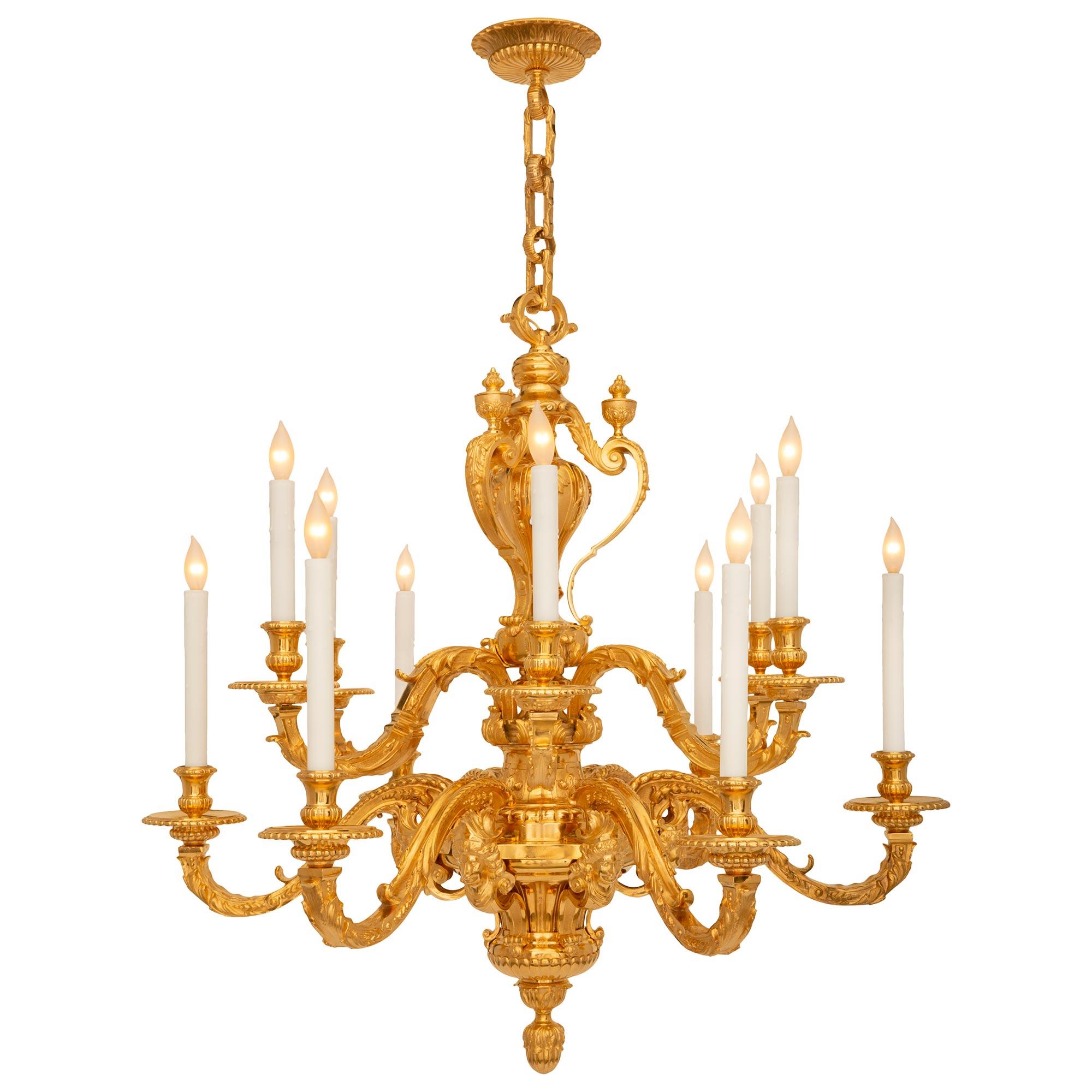 An impressive and large scale French 19th century Louis XIV st. ormolu chandelier. The twelve arm chandelier is centered by a striking bottom foliate finial below the reeded and elegantly curved body with exceptional scrolled movements with