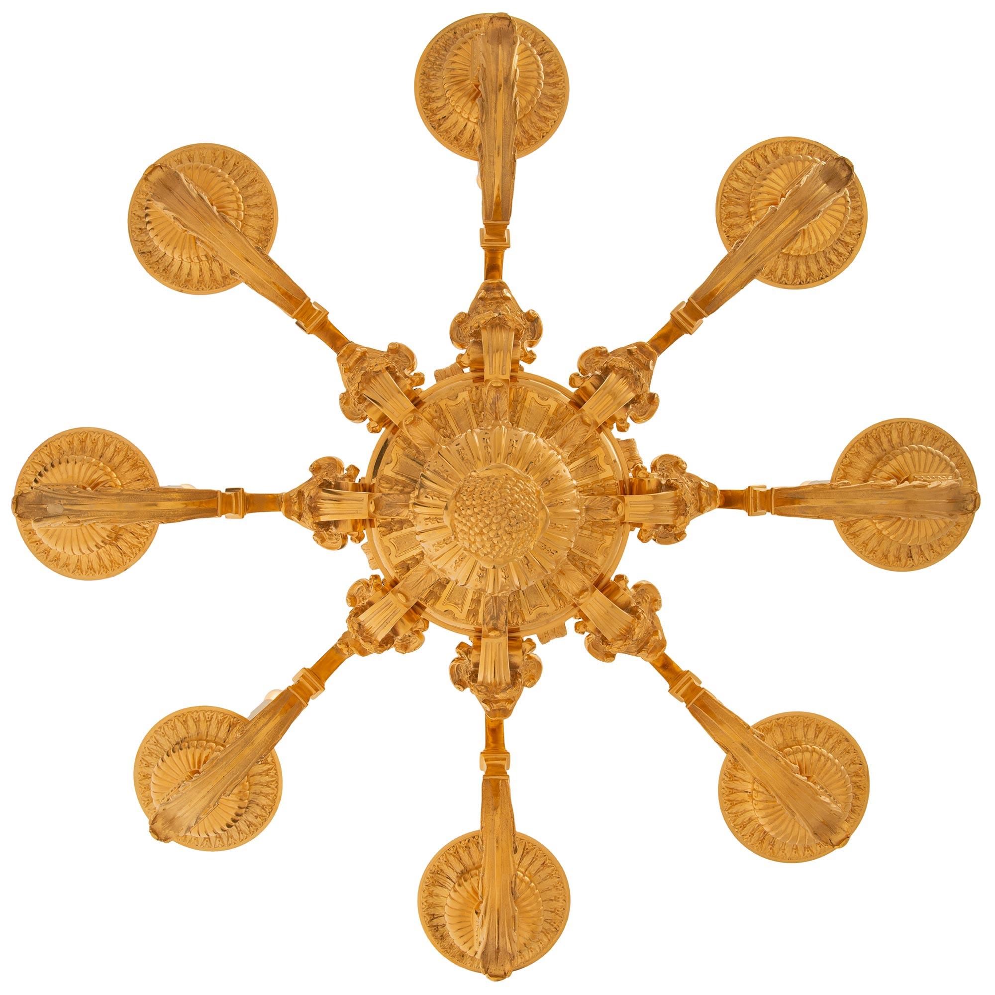 Magnifique lustre en bronze doré de style Louis XIV du XIXe siècle. Le lustre à huit branches est centré par un remarquable fleuron en forme de gland à feuillage inversé, situé au-dessous de motifs cannelés à partir desquels les branches se