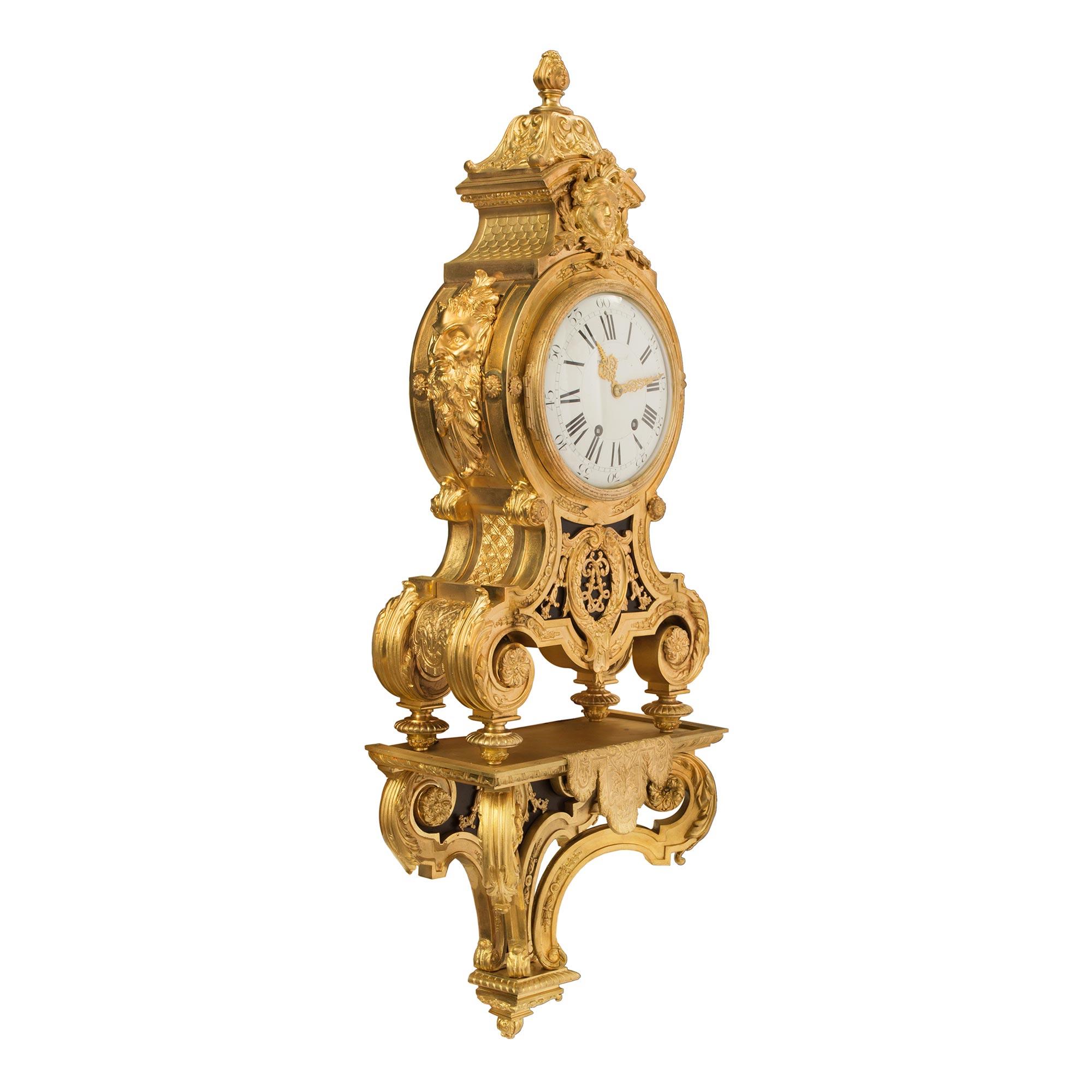 A most impressive and high quality French 19th century Louis XIV st. ormolu cartel clock. The clock is raised on its original wall mounting stand with a lovely foliate bottom finial and elegant scrolled tapered movements. Adorned with finely chased