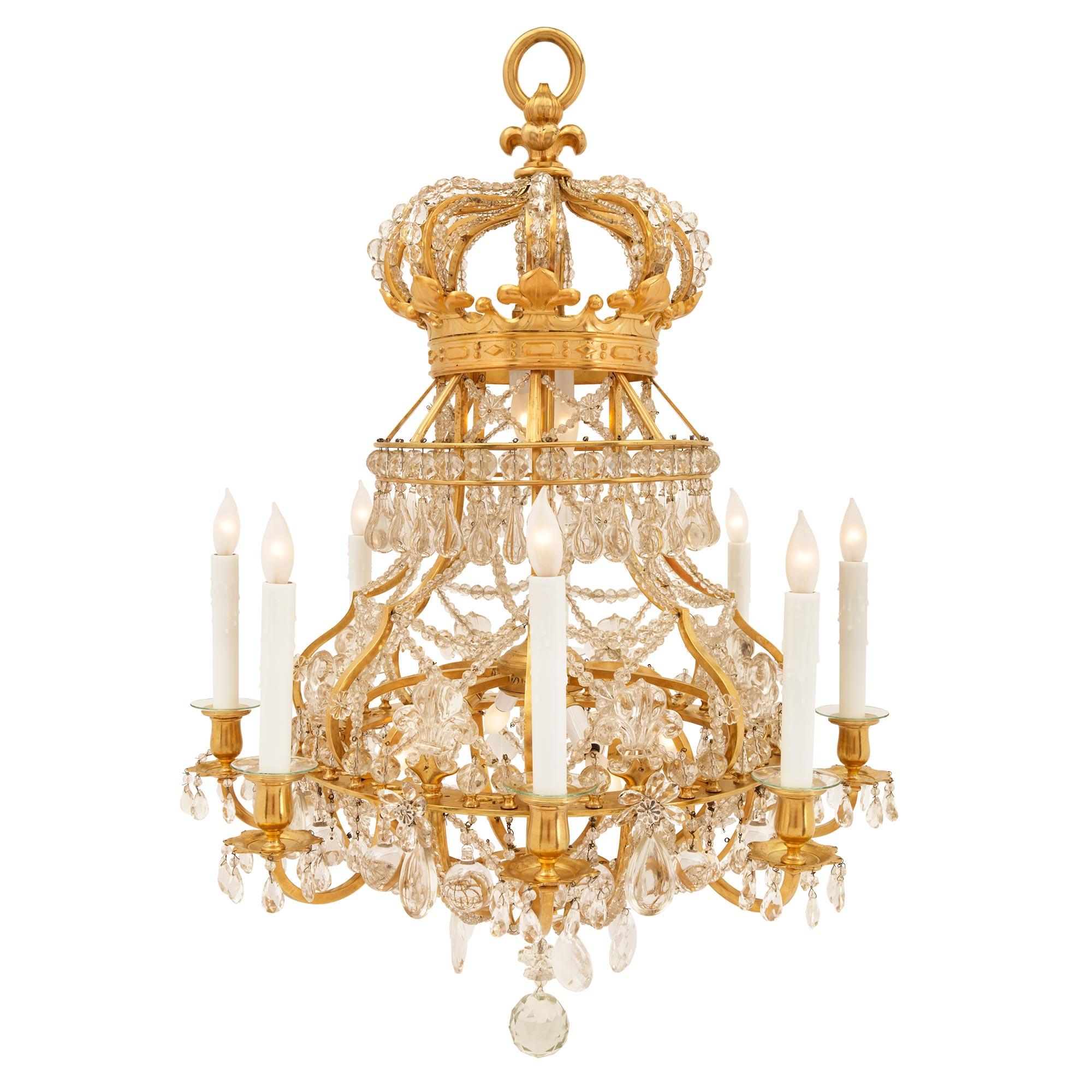 A sensational French 19th century Louis XIV st. ormolu, crystal and beaded glass eight arm fourteen light chandelier after a royal model. The chandelier is centered by a beautiful solid cut crystal ball pendant amidst lovely cut crystal pendants.