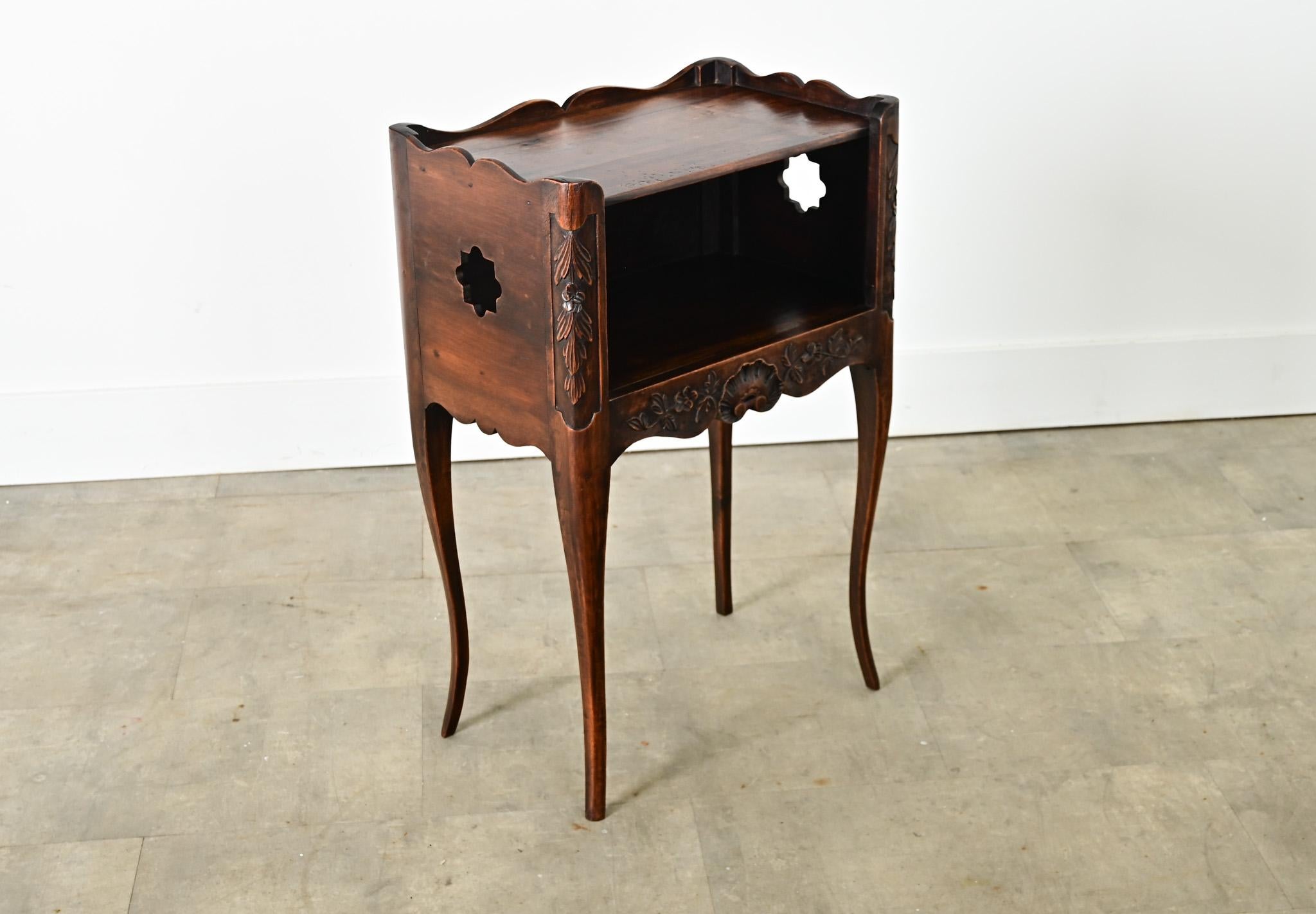 An enchanting Louis XV style 19th century oak table de chevet, or bedside table, with expressive rococo carvings around the case. The lightly patinated top surface is framed by an undulating gallery on three sides and flat above the compartment
