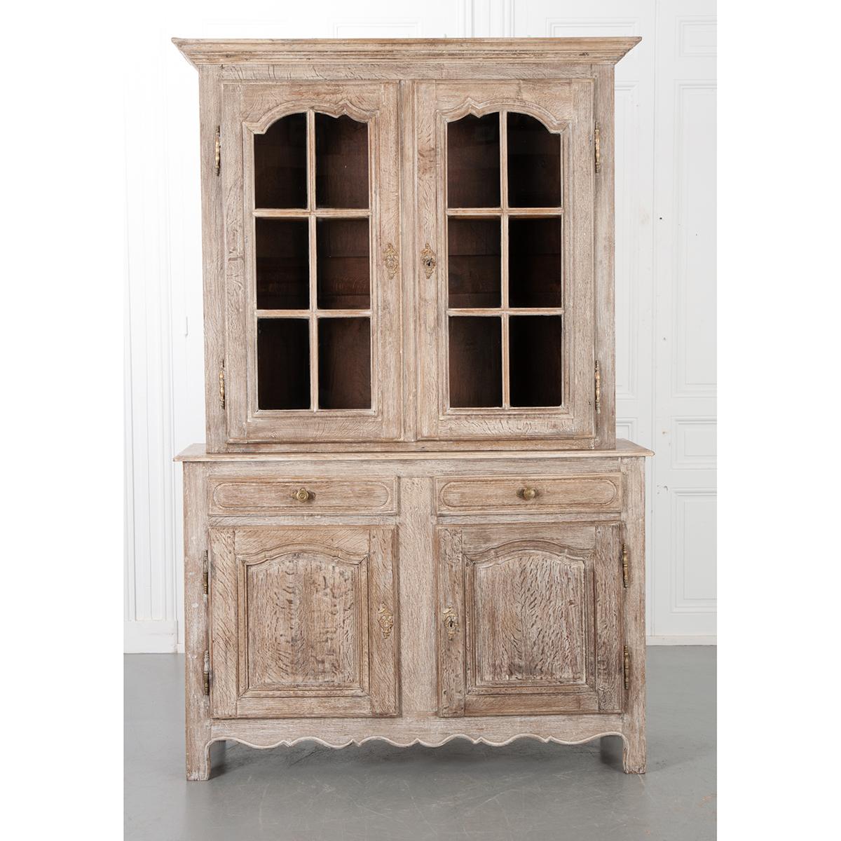This exquisite French buffet a Deux Corps provides plenty of storage space! Made of oak and given a pickle finish, you can see the stunning grain of the wood throughout. Four matching brass Escutcheons are original and depict a peacock and floral
