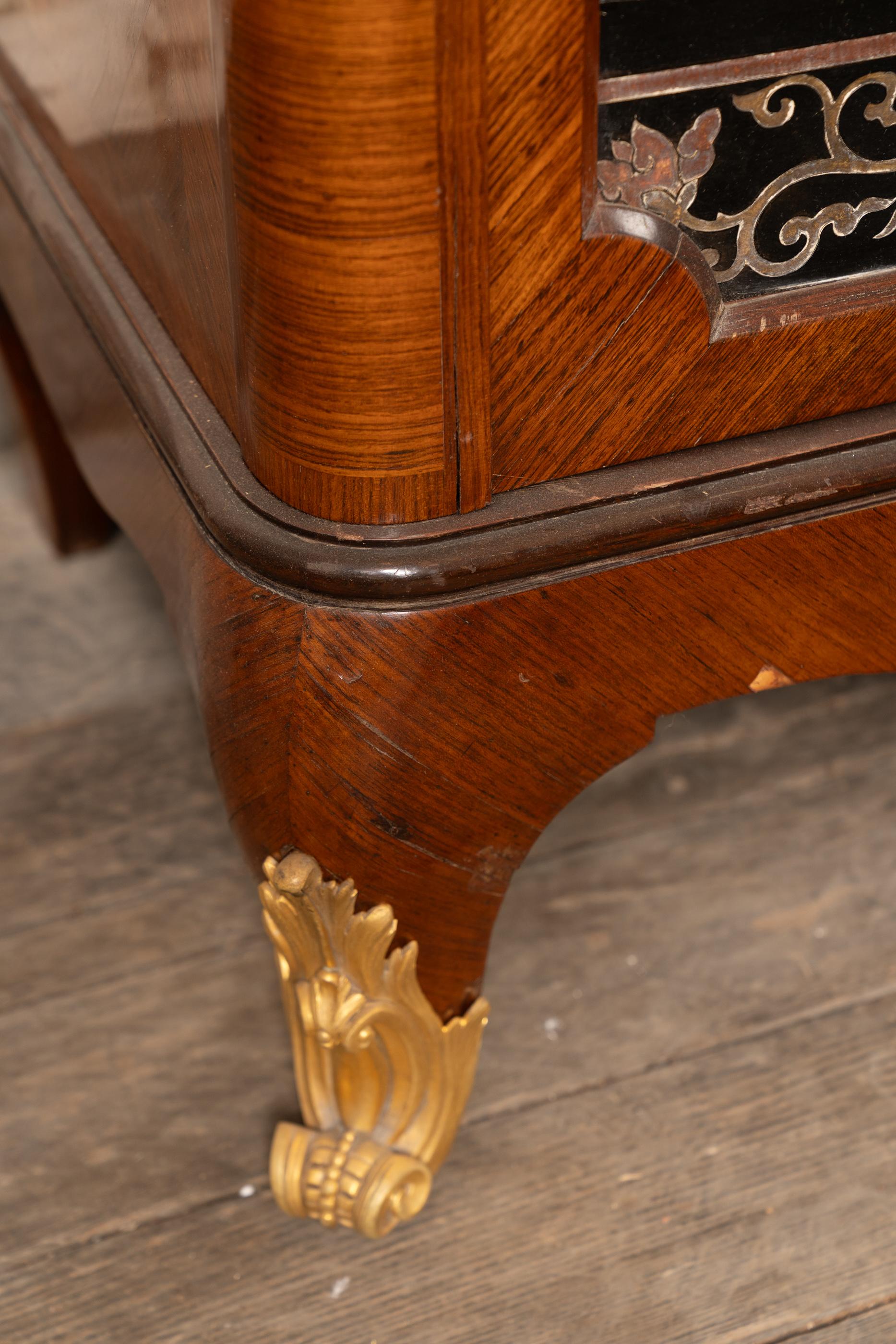 This magnificent Louis XV satinwood cabinet is trimmed with dark wood and mounted with bronze. The french antique piece dates back to the 19th century and features two grilled doors alongside two solid doors fashioned from Coromandel panels. It was