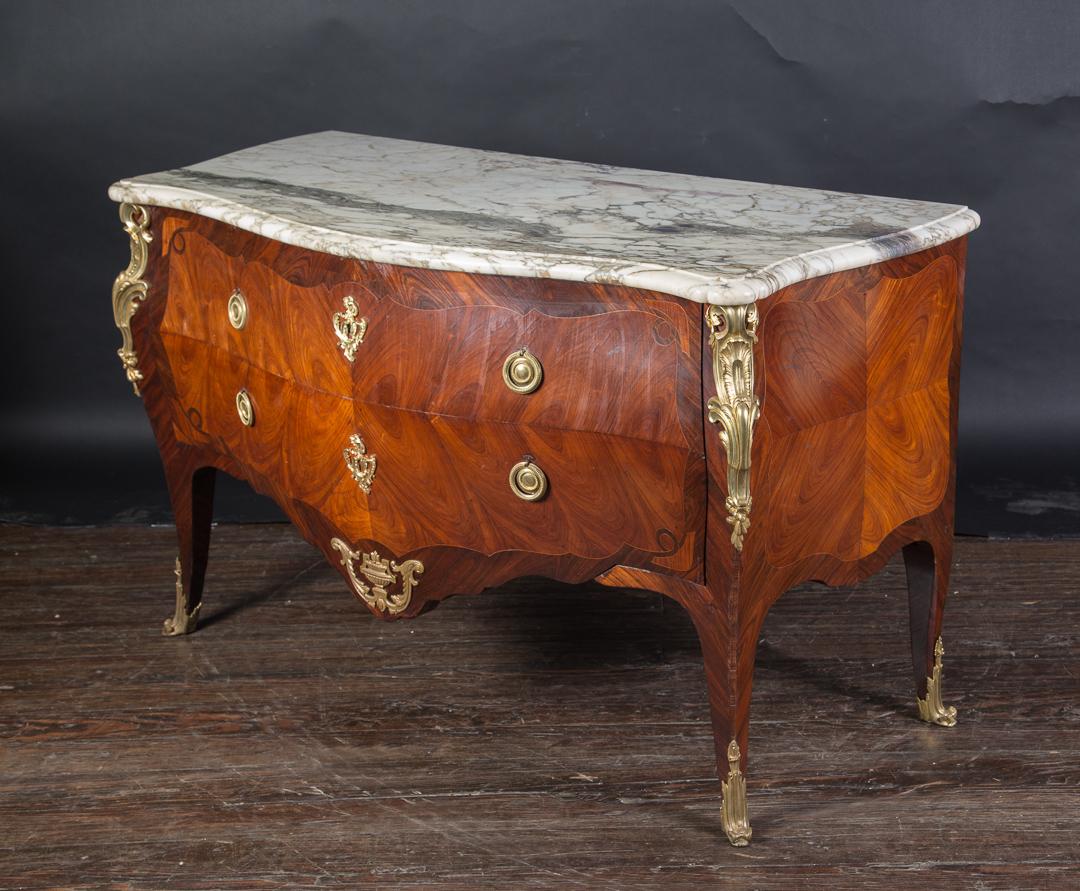 Diese prächtige Louis XV Bombé Kommode verfügt über zwei Schubladen mit durchbrochenen Bronze d'ore Schubladenzügen und detaillierten Wappenschildern. Das antike französische Stück stammt aus dem 19. Jahrhundert und beherbergt durchbrochene