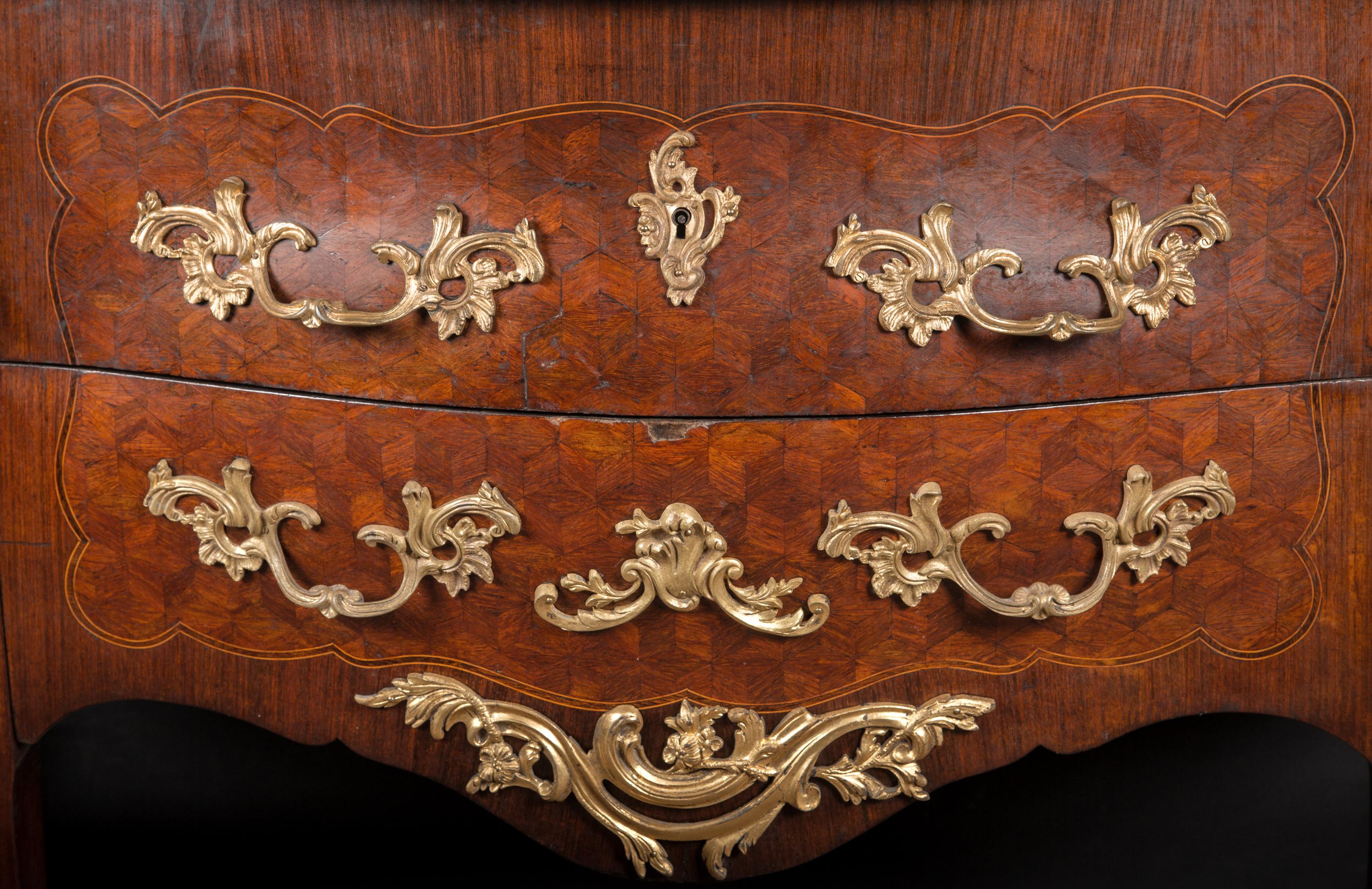 Questa splendida commode Luigi XV Bombé è dotata di due cassetti con tiretti in bronzo traforato e scanalature dettagliate. Questo pezzo d'antiquariato francese risale al XIX secolo e ospita delle montature in bronzo traforato su ciascuno degli