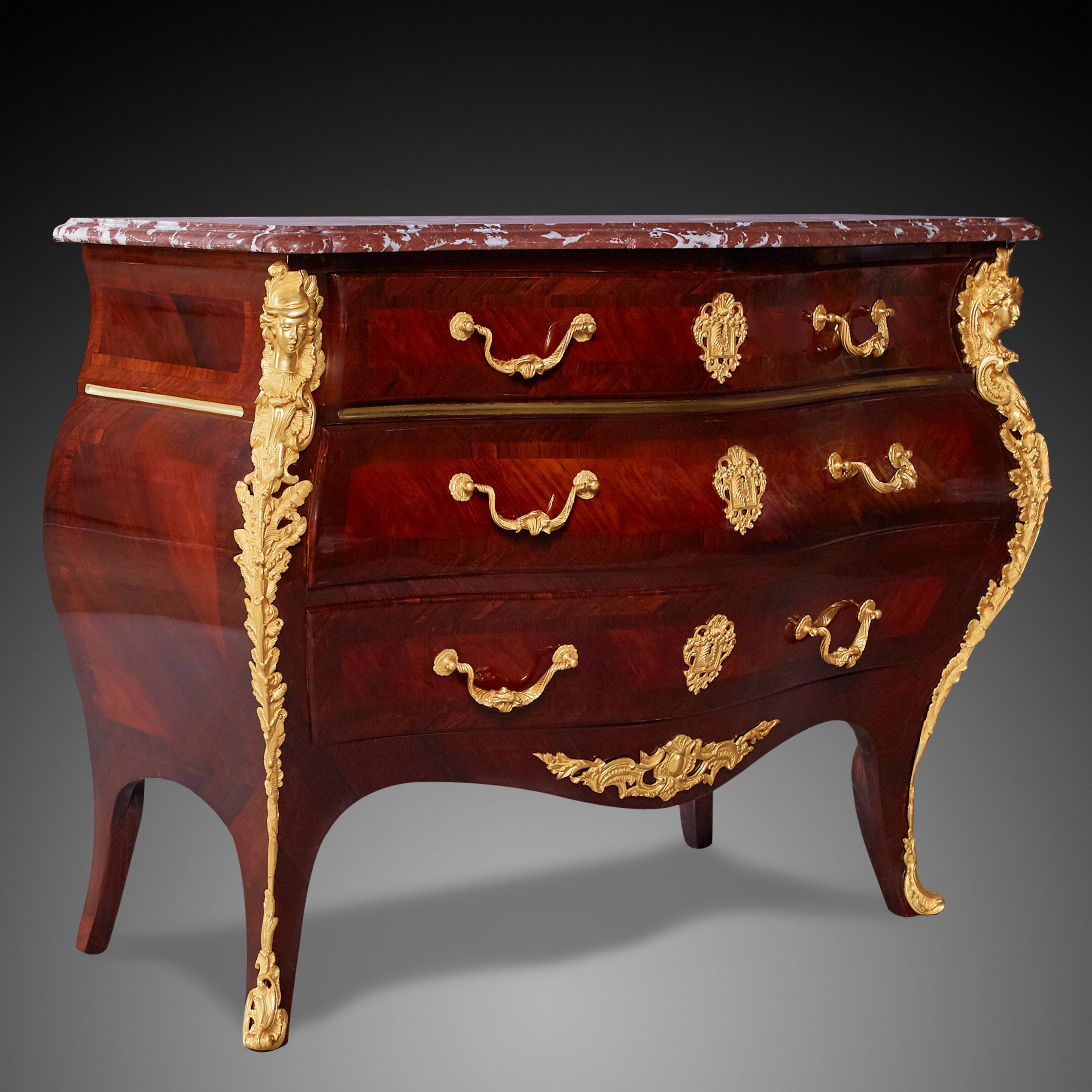 A Louis XV Style commode with a molded marble top above three long drawers, raised on cabriole legs, having a generous curve on the facade and on the sides. Each drawer has two ormolu handles and one keyhole, flanked by curved uprights surmounted by