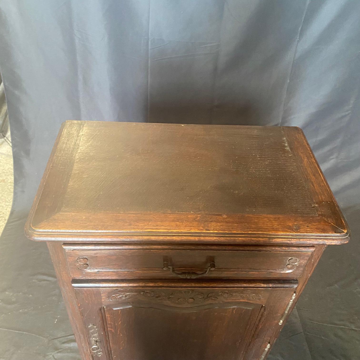 Un buffet francese in rovere massiccio del periodo Luigi XV con una coppia di ante intagliate che poggiano su cerniere a barile in acciaio con placchette tagliate a mano e serratura e chiave funzionanti. L'interno presenta un ripiano profondo e un