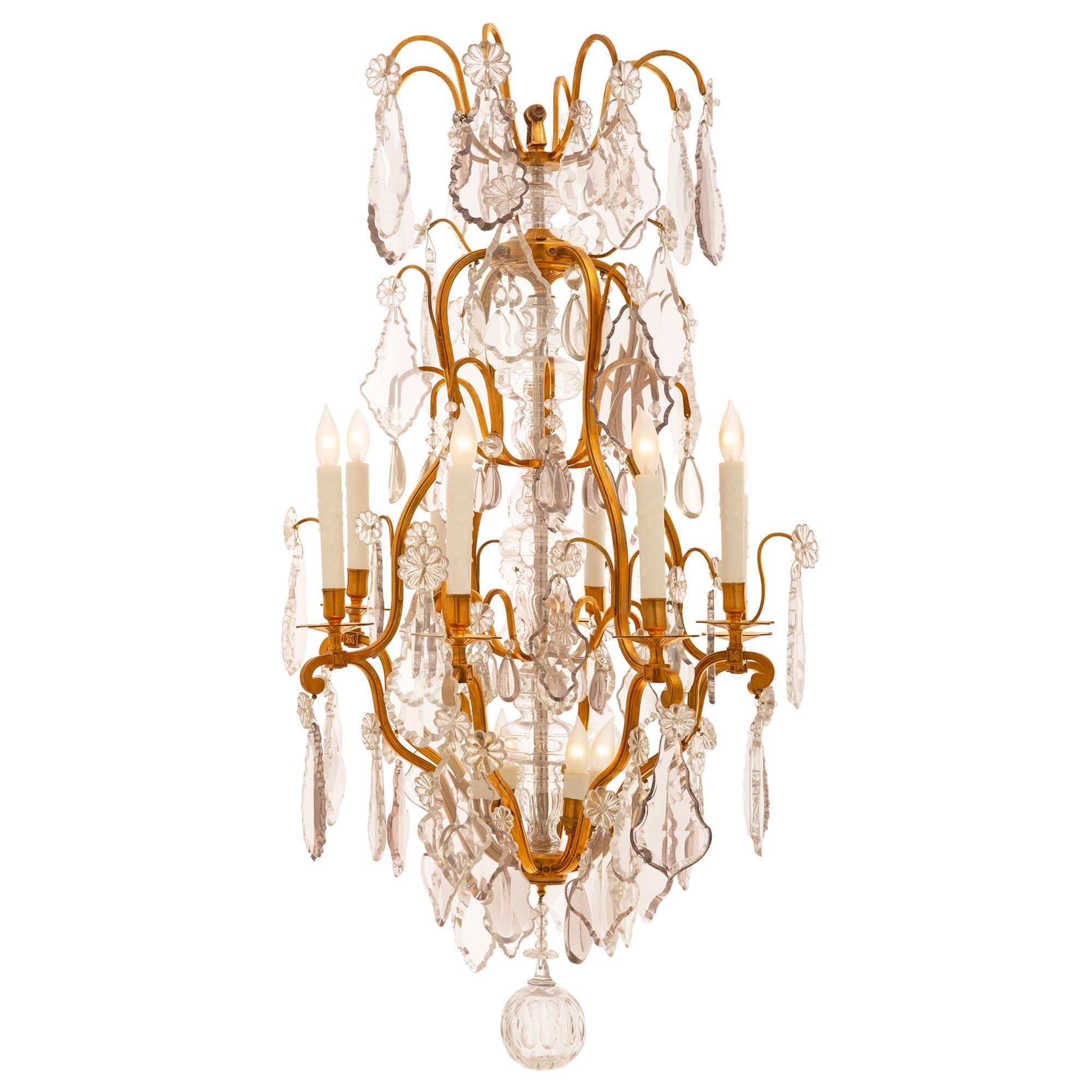 An exceptional French 19th century Louis XV st. Baccarat crystal and ormolu chandelier. The eight arm twelve light chandelier is centered by a beautiful cut crystal ball below the elegantly scrolled cage adorned with a stunning array of clear,