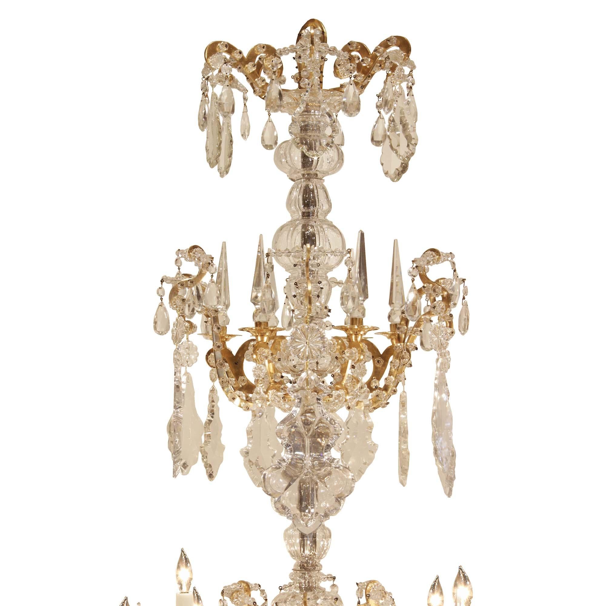 A spectacular and monumental French 19th century Louis XV st. Baccarat crystal chandelier. This chandelier has a central crystal ball hanging from a crystal base, below six elaborately scrolled arms that end in three cut crystal candelcups each, and