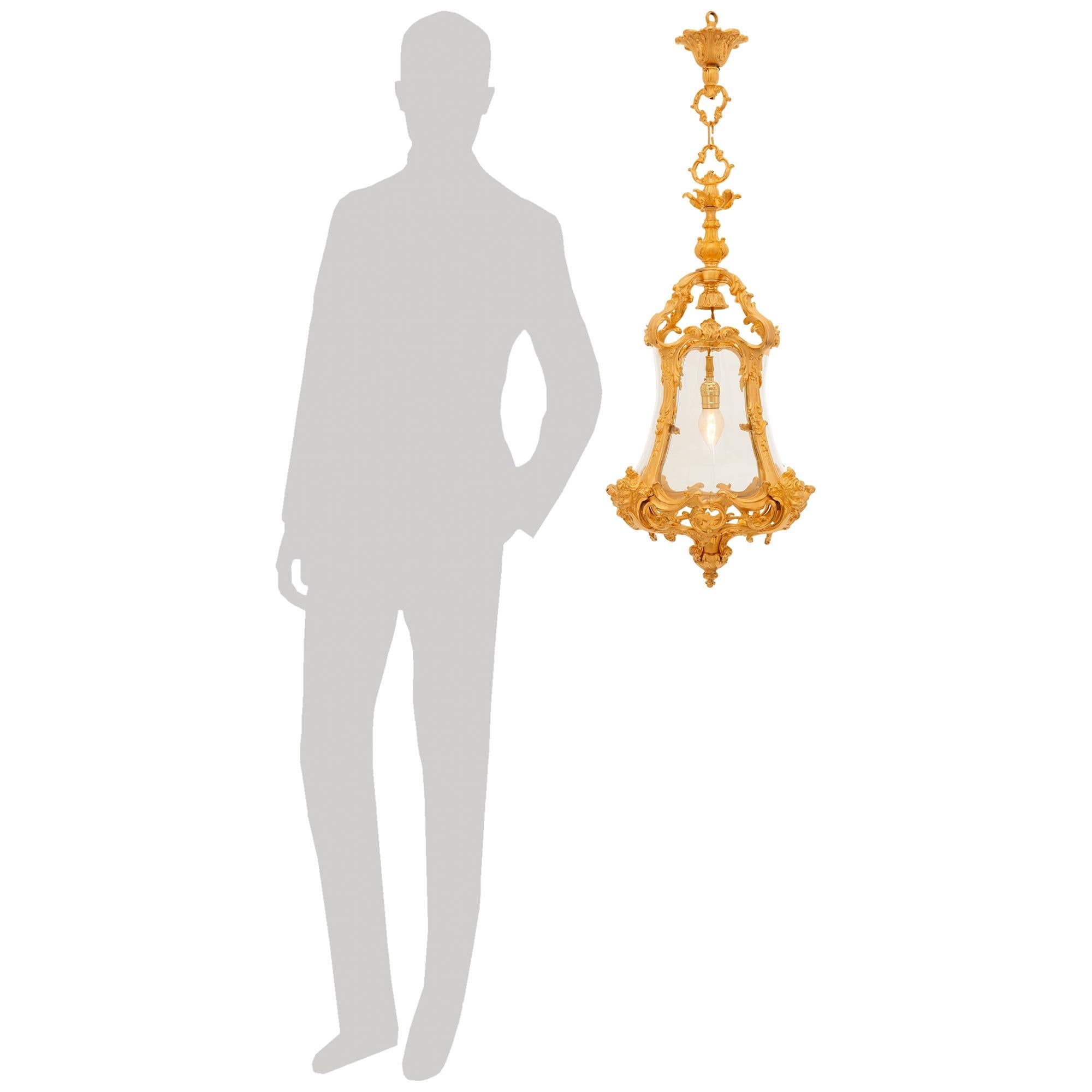 Lanterne en bronze doré et verre d'époque Belle Epoque, de style Louis XV, du XIXe siècle. Cette étonnante lanterne est centrée à la base par un fleuron en bronze doré menant à la cage de verre fermée sur quatre côtés. Des rinceaux de feuilles