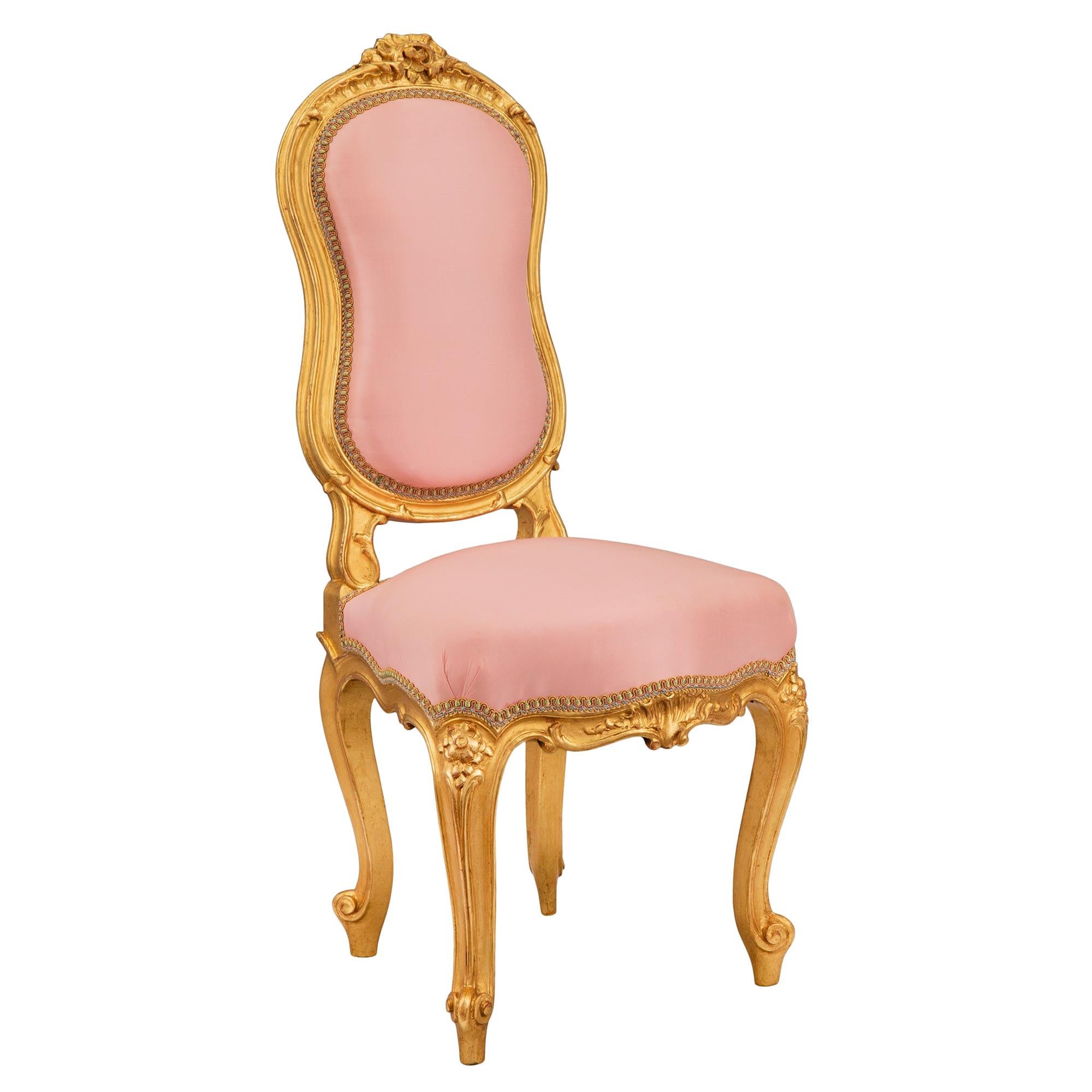 A very charming French 19th century Louis XV st. child's chair. The chair is raised by fine cabriole legs with elegant scrolled feet. Above each leg is a lovely foliate carving, centered by an arbalest shaped frieze, with a striking carved seashell