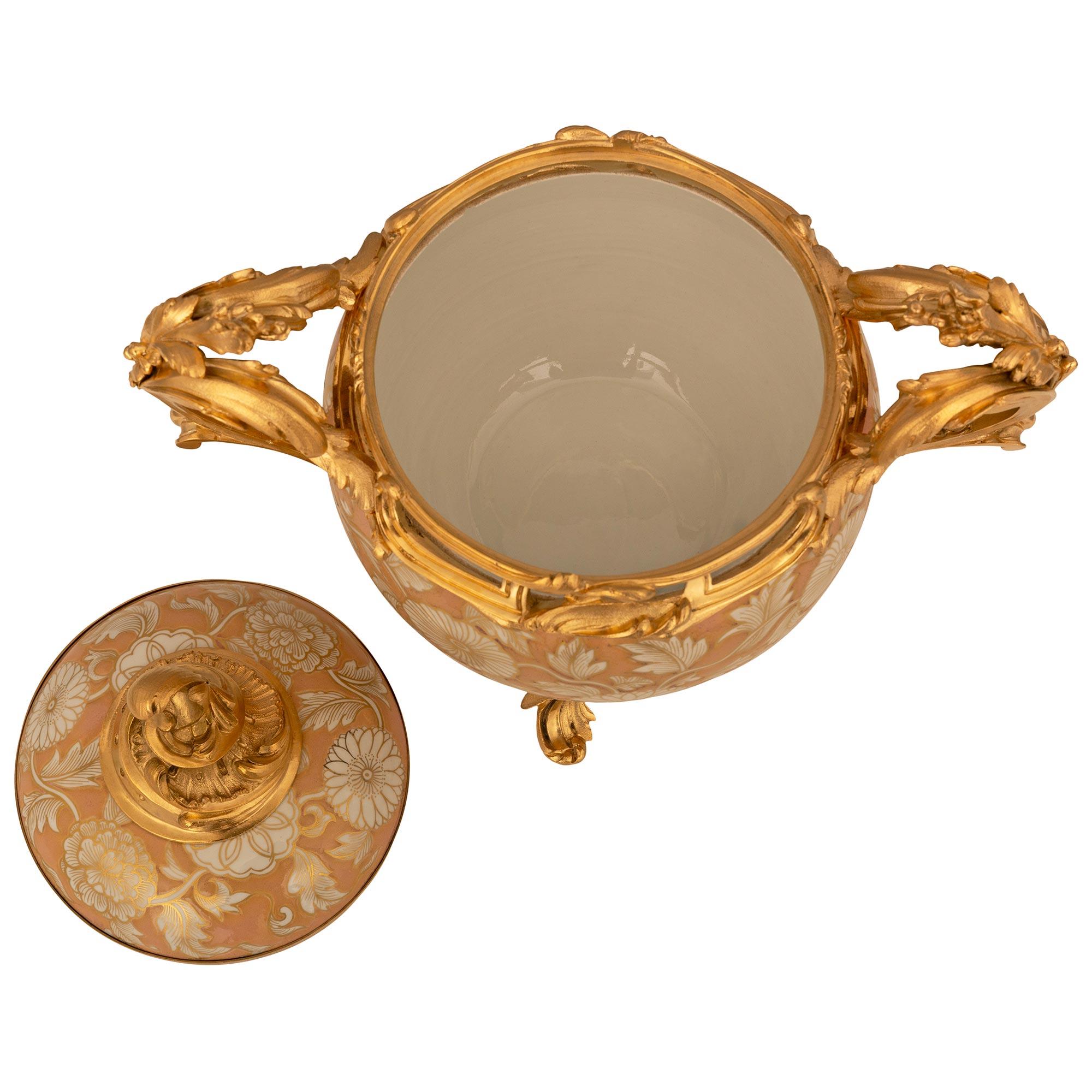 A beautifully detailed French 19th century Louis XV st. Chinese export porcelain and Ormolu lidded urn. This wonderful lidded pot pourri urn is supported by four foliate Ormolu feet connected to the wonderfully and richly chases handles on either