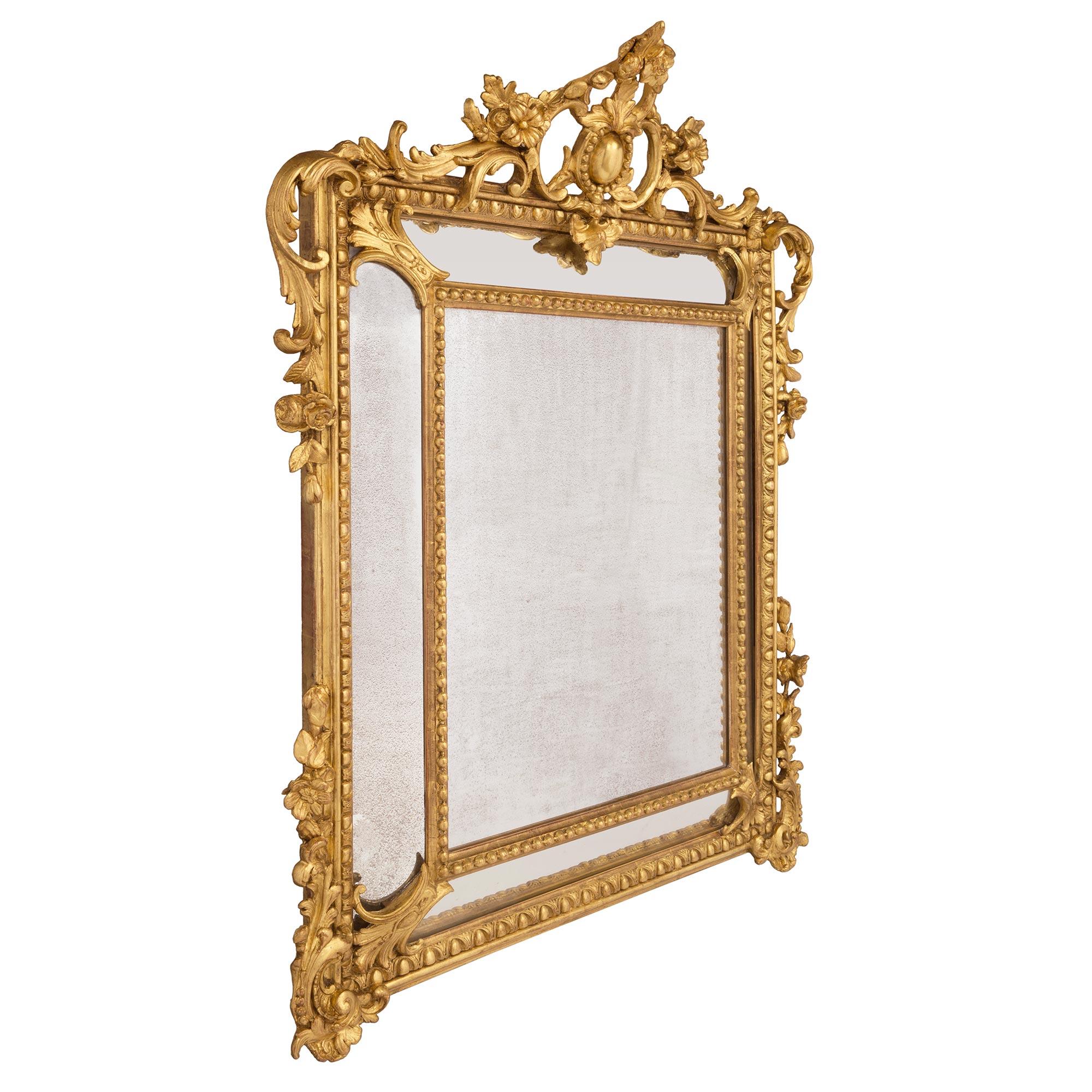 A striking French 19th century Louis XV st. double framed giltwood mirror. The original central mirror plate and four outer mirror plates are each framed within a fine beaded and Les Oves border. At each corner are lovely floral reserves and