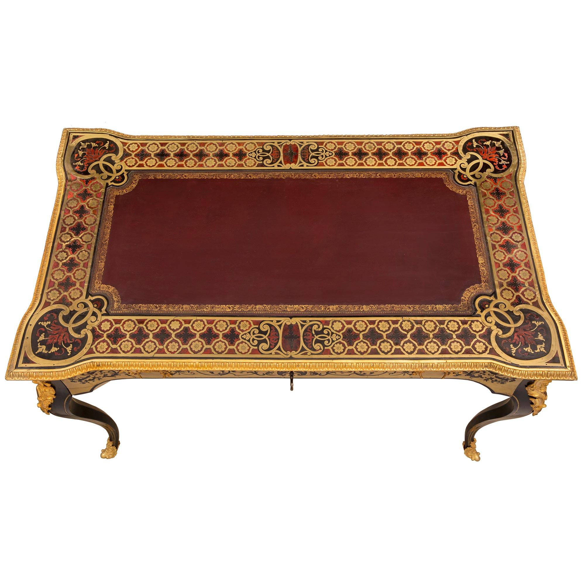 A stunning and unique French 19th century Louis XV st. ebony, tortoiseshell, brass, and leather Boulle st. desk. The desk is raised by four elegant cabriole legs with fine fitted foliate ormolu sabots, lovely brass inlaid filets, and striking richly