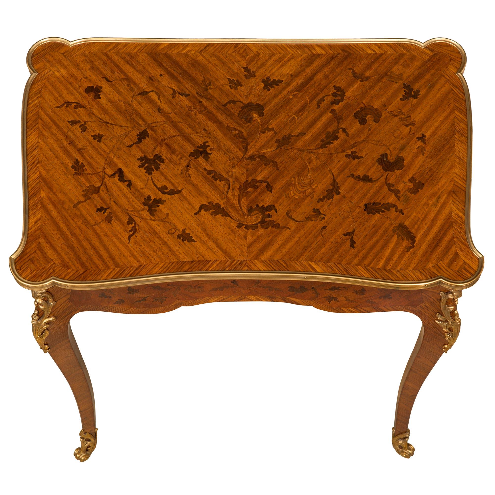 A beautiful and very unique French 19th century Louis XV st. Kingwood, Tulipwood, and ormolu flip top games table. The table is raised by elegant slender cabriole legs with high quality pierced scrolled foliate fitted ormolu sabots and richly chased