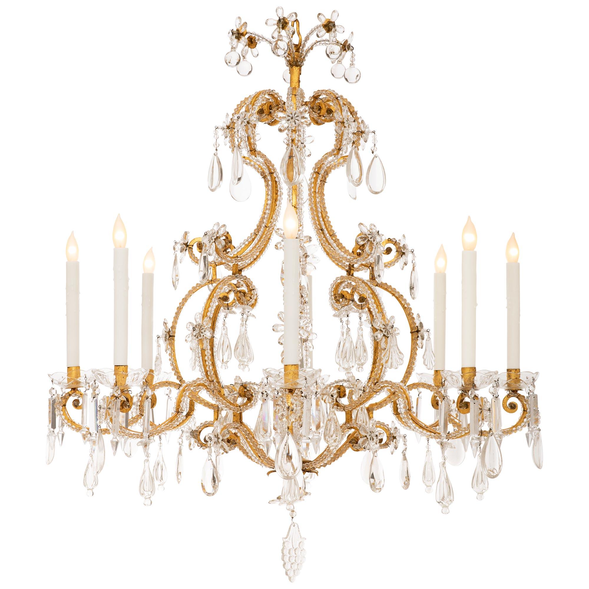 An elegant and most decorative French 19th century Louis XV st. Gilt Metal and cut Glass chandelier. This exquisite and large scaled eight arm chandelier is centered by a berried Glass bottom finial which hangs below the base of the cage. The cage