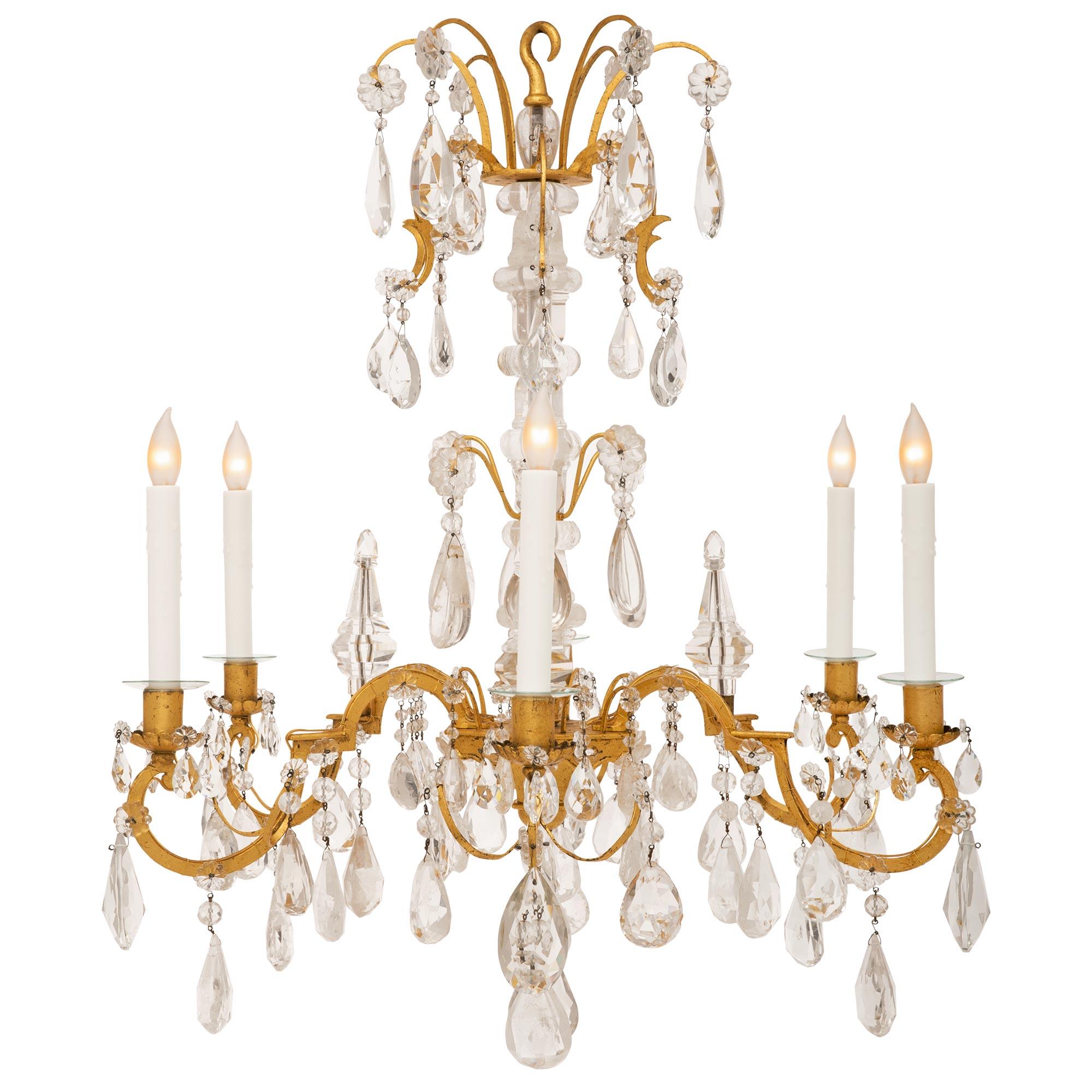 A beautiful French 19th century Louis XV st. gilt metal and rock crystal chandelier. The six arm chandelier is centered by a solid bottom crystal pendant below an elegant mottled lightly curved support and surrounded by a remarkable array of most