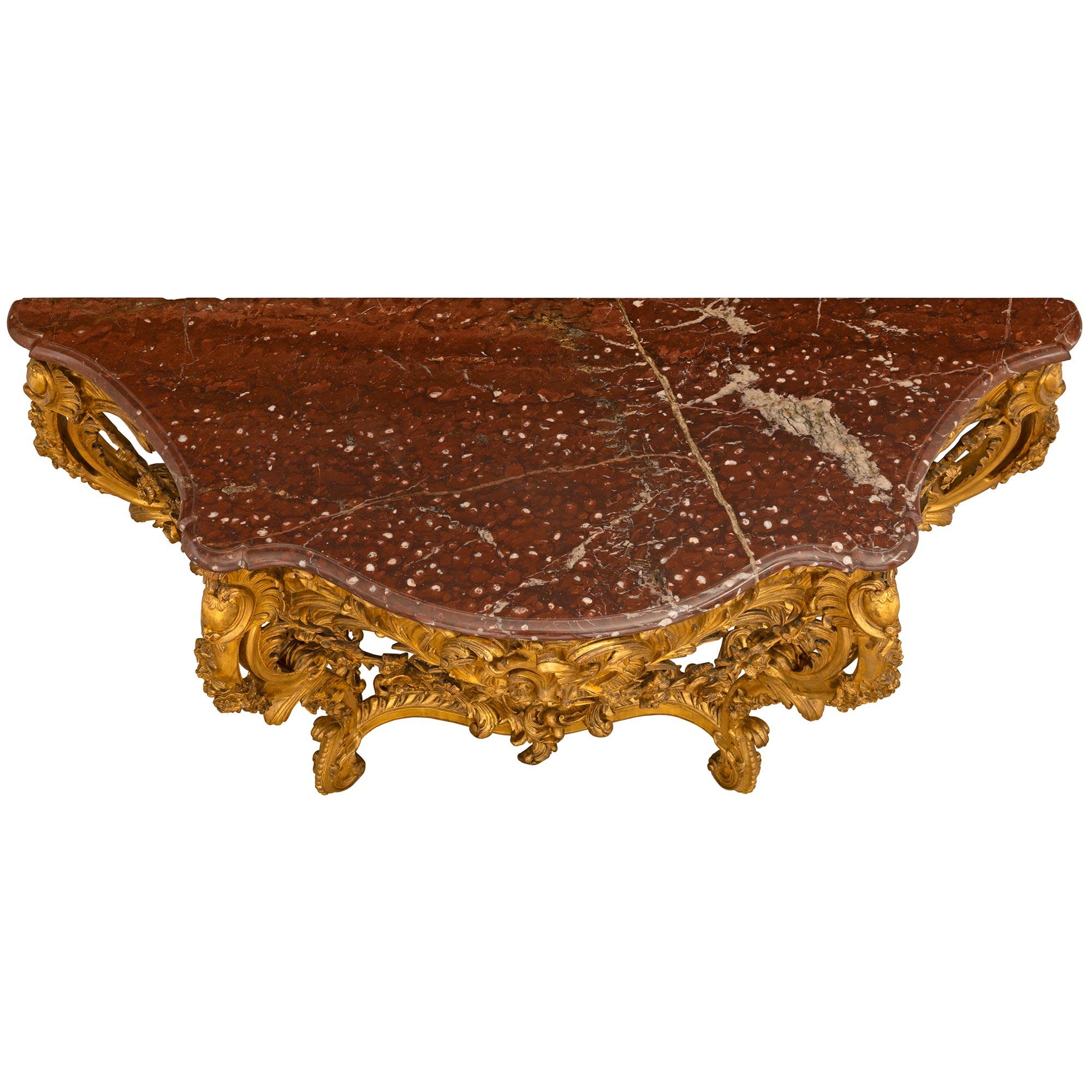 An impressive and extremely high quality French 19h century Louis XV st. giltwood freestanding console with the original marble top. The console is raise by sensational cabriole legs with exquisitely carved foliate movements, floral accents and a