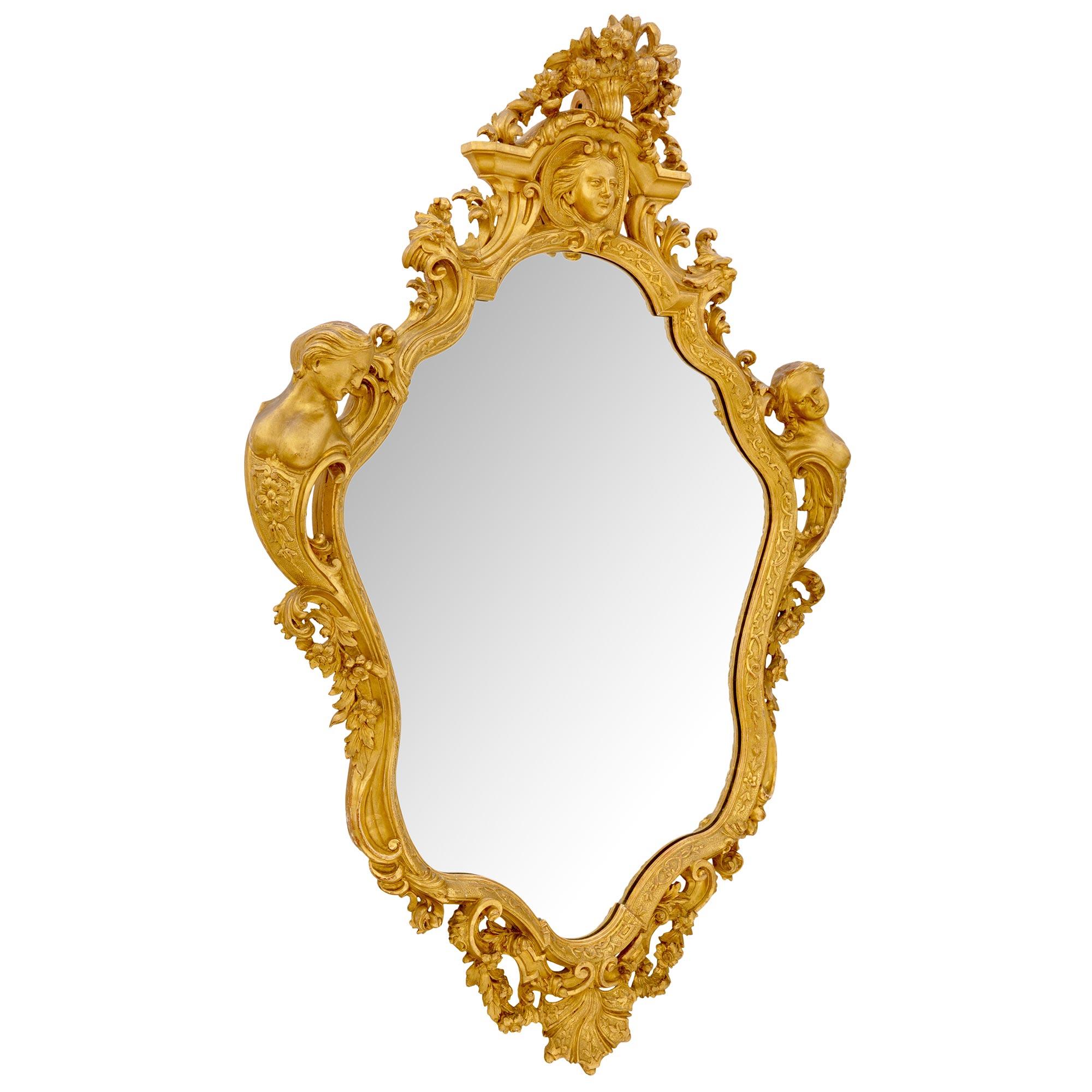 A magnificent French 19th century Louis XV st. giltwood mirror. The original mirror plate is framed within a most decorative scallop shaped border with lovely etched floral designs. At the base is an impressive seashell reserve centered by charming