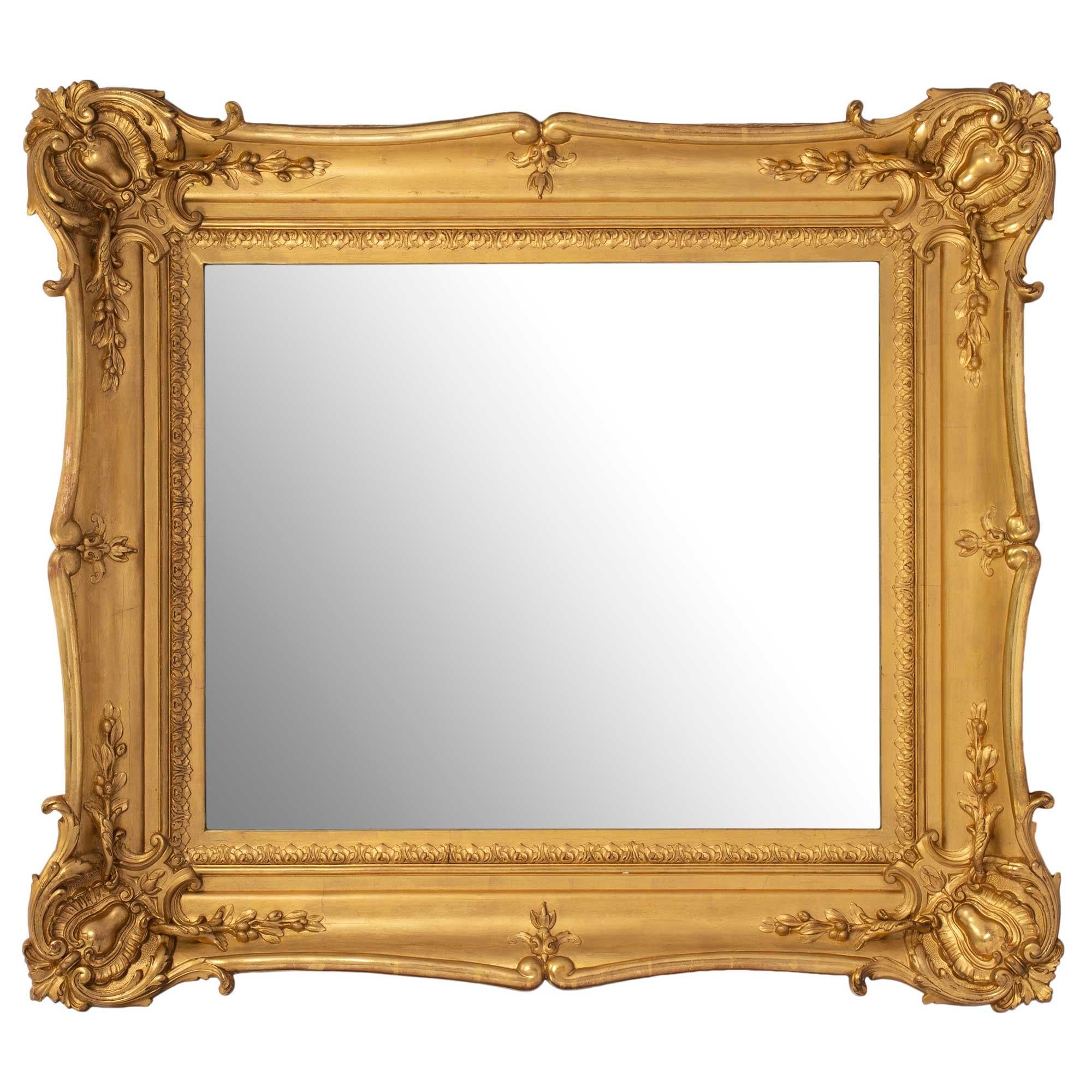 Une belle paire de miroirs en bois doré de style Louis XV du 19ème siècle. Chaque miroir présente une bordure sculptée de feuillages dans le cadre à volutes. Le joli cadre en bois doré présentait un merveilleux mouvement avec de grandes sculptures