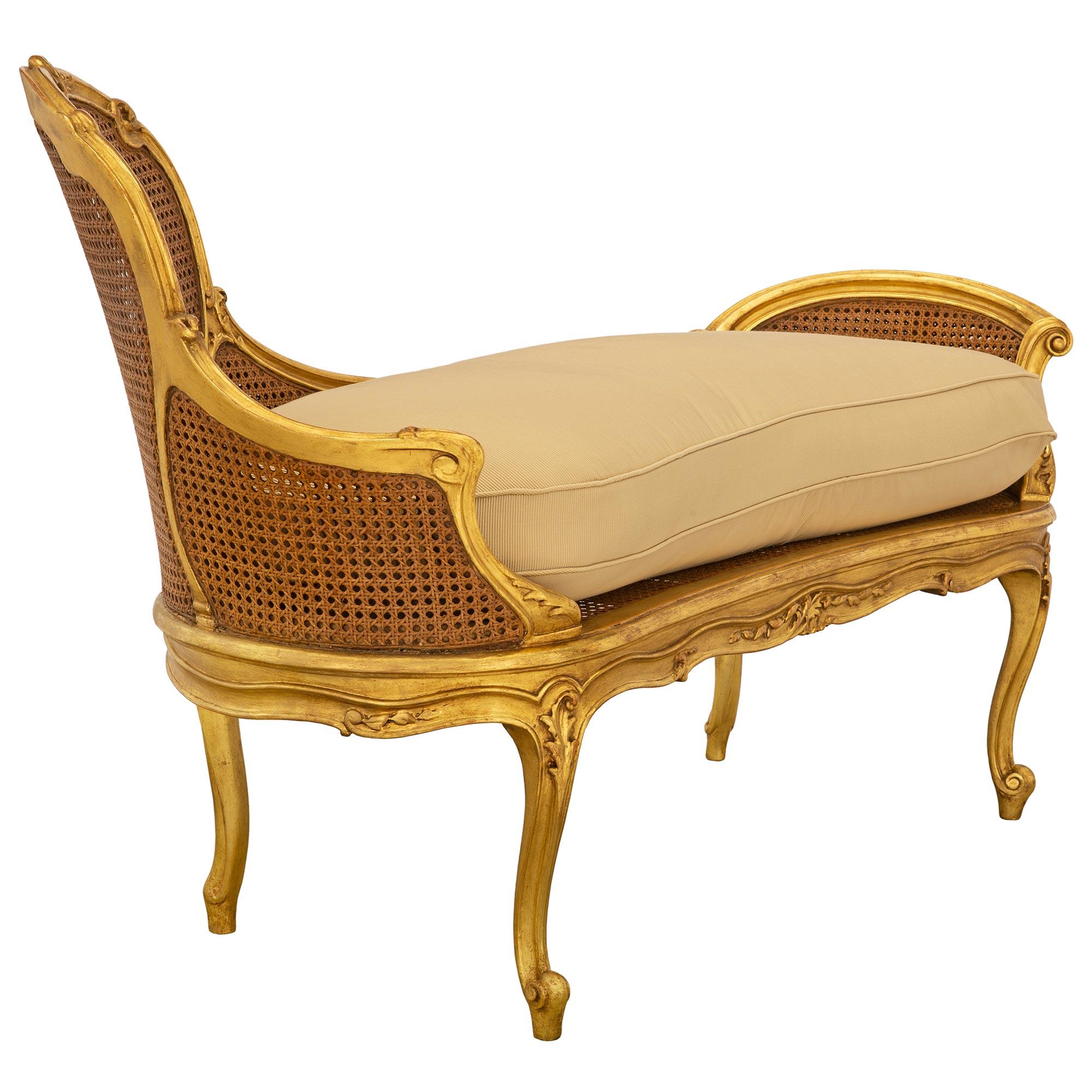 A beautiful and most unique French 19th century Louis XV st. giltwood settee. The small scale settee is raised by elegant slender cabriole legs with fine scrolled feet, corner acanthus leaf carvings, and lovely mottled fillets which extend up each