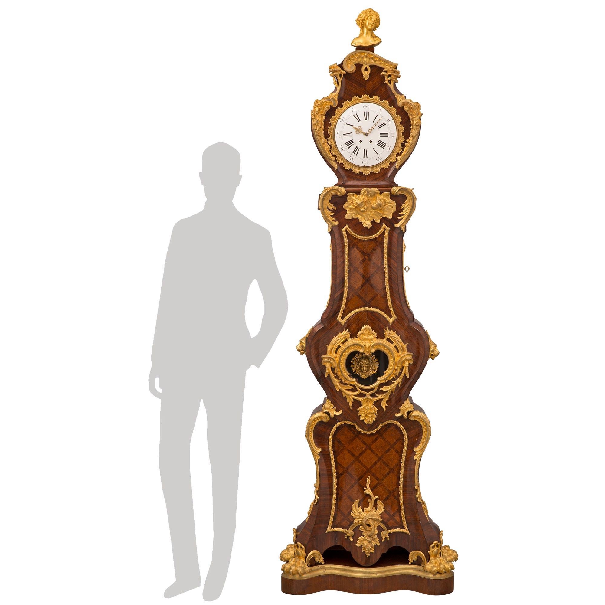 A spectacular and extremely high quality French mid-19th century Louis XV st. kingwood, tulipwood, and ormolu grandfather clock. The clock is raised by a fine scalloped shaped kingwood base with a mottled wrap around ormolu band and handsome richly