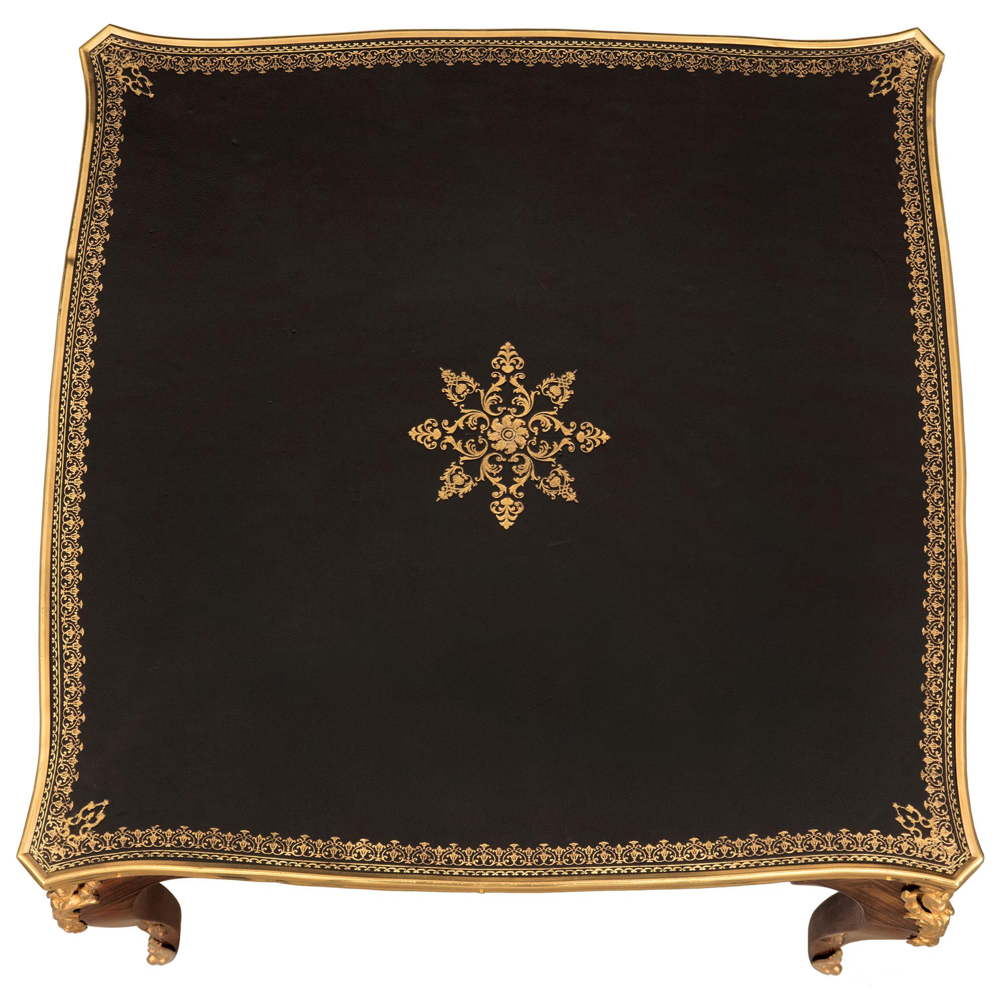 Une très élégante table basse française du 19ème siècle en bois de roi et bronze doré. La table carrée est surélevée par de minces pieds cabriole avec des sabots en bronze doré finement ciselé et de remarquables montures d'angle en forme de
