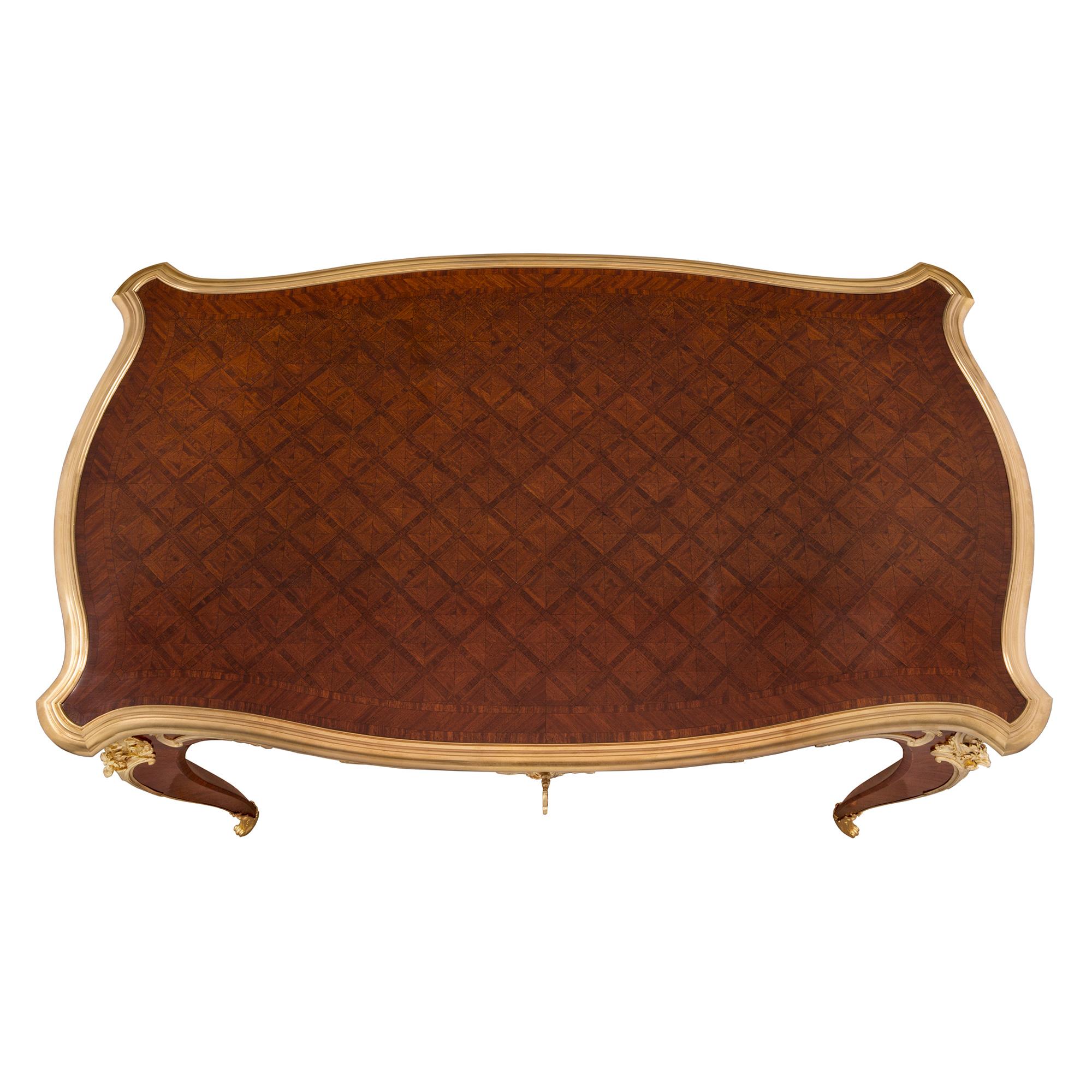 Una splendida scrivania francese del XIX secolo in legno massiccio Luigi XV e ormeggio di altissima qualità, attribuita a François Linke. La scrivania è sollevata da eleganti gambe cabriole con sabot foliati. I raffinati scivoli in ormolu salgono su
