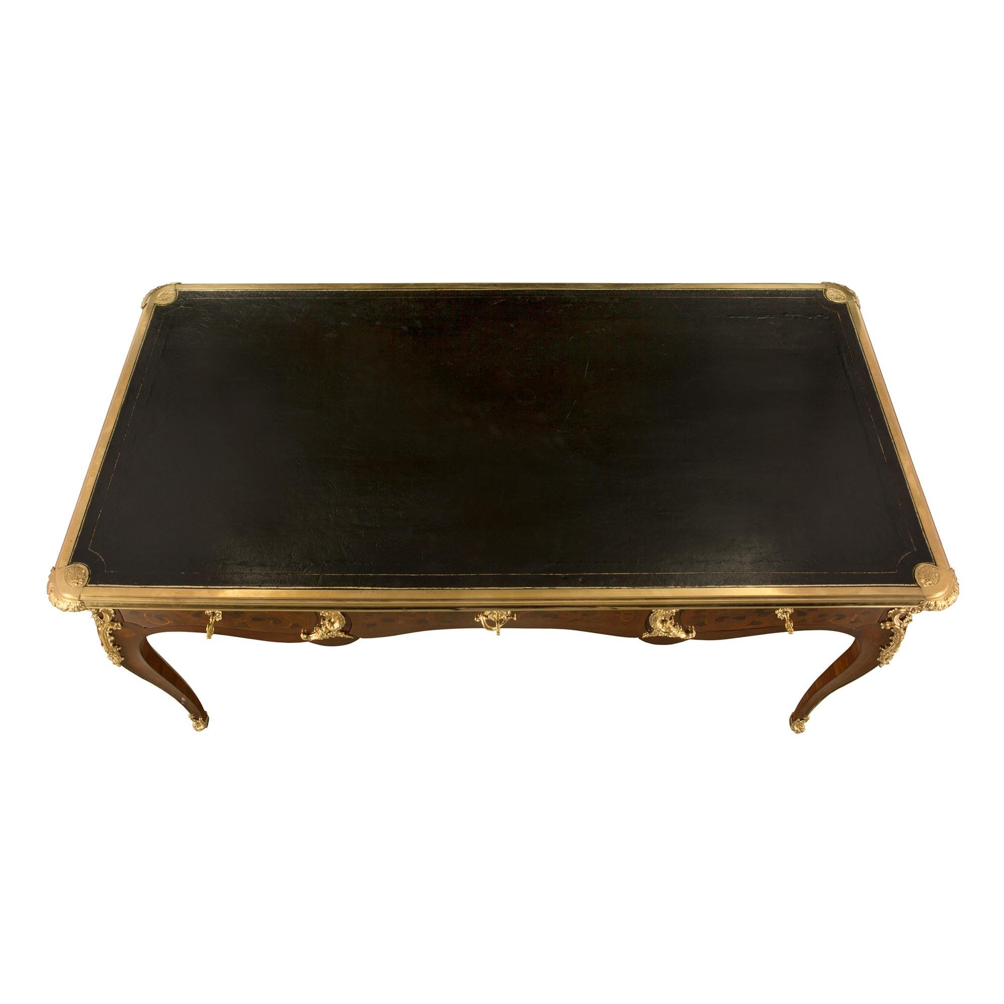 A most elegant French 19th century Louis XV st. kingwood and ormolu desk. The desk is raised by beautiful cabriole legs with fine wrap around ormolu sabots and a striking ormolu fillet which leads up each leg to richly chased pierced foliate corner