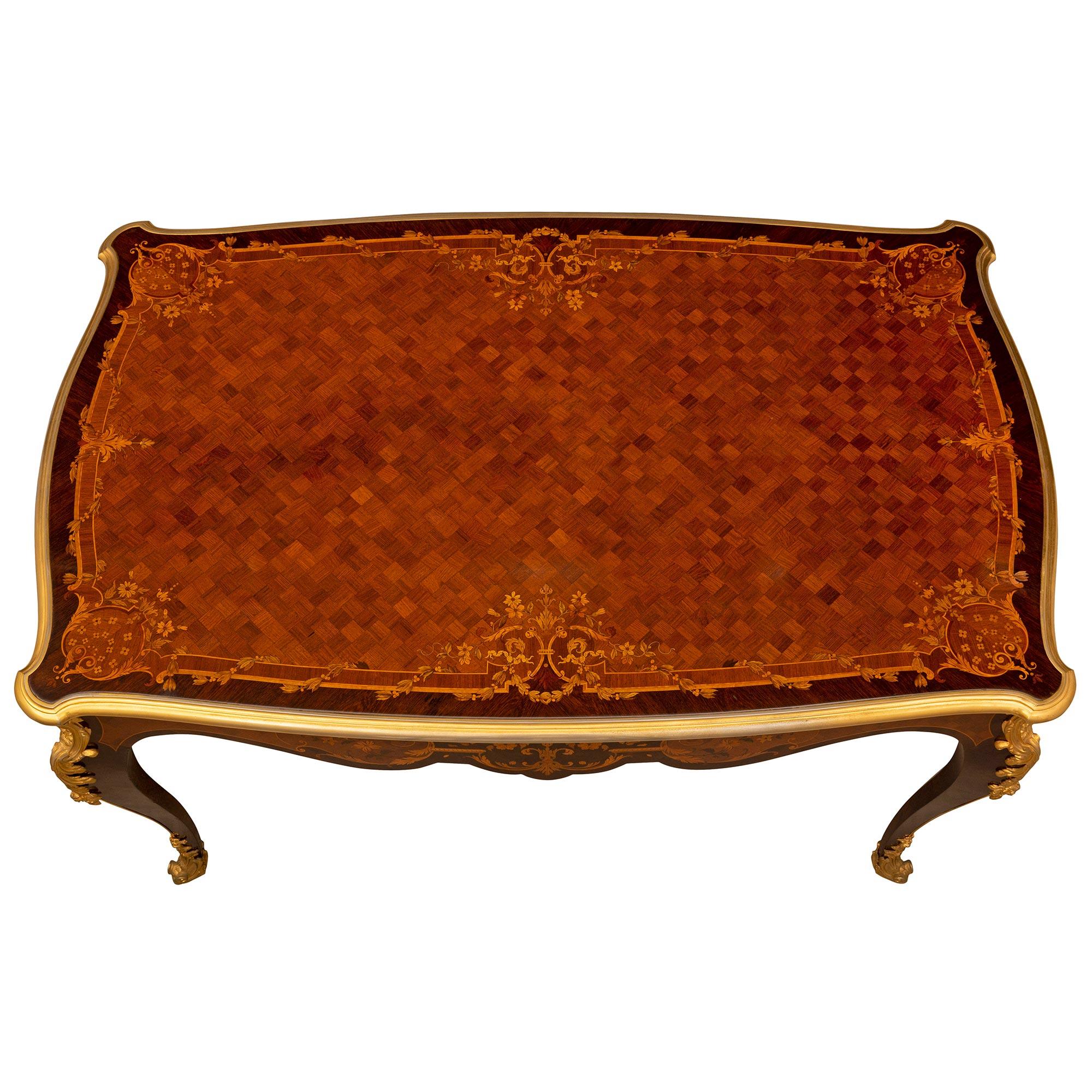 Une élégante et très haute qualité de table de centre Louis XV du 19ème siècle en bois de roi, bois exotique et bronze doré. La table rectangulaire signée BURY est surélevée par d'impressionnants pieds cabriole avec de fins sabots enveloppants en