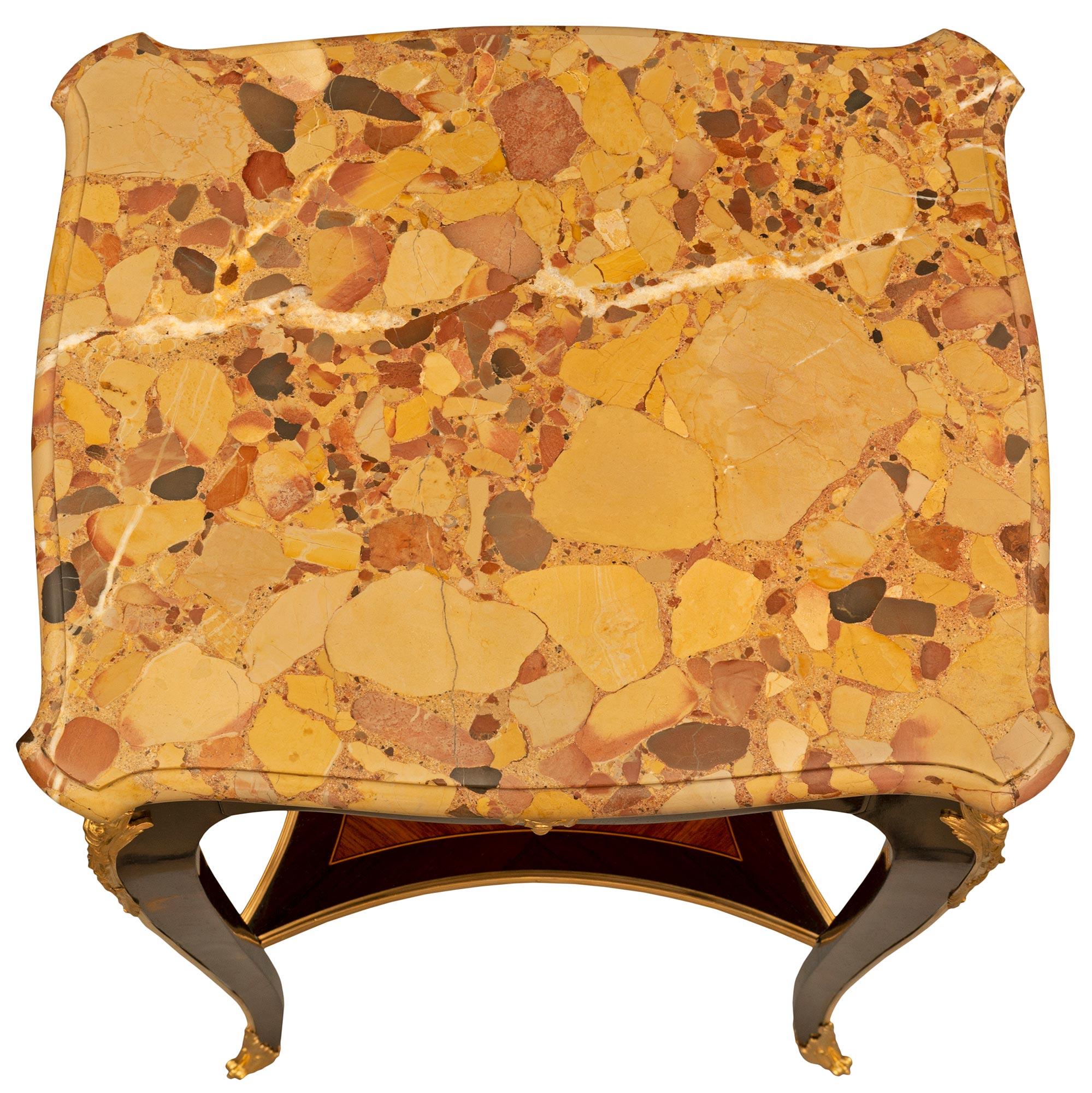 Une élégante table d'appoint de grande qualité, datant du XIXe siècle, en bois de roi, bronze doré et brèche d'Alep. La table d'appoint rectangulaire à un tiroir est surélevée par de minces pieds cabriole avec de fins sabots en bronze ciselé et orné