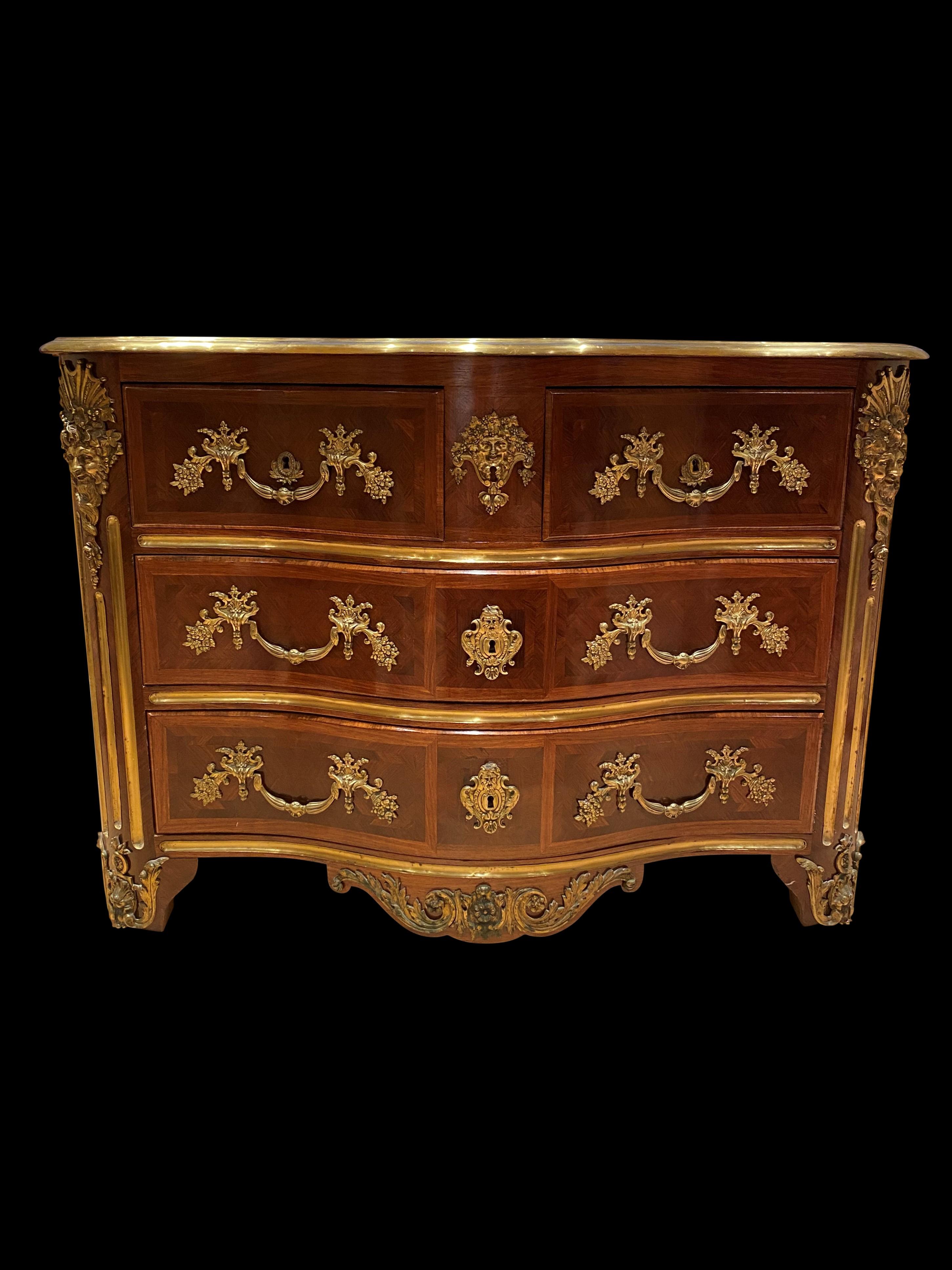 A stunning French 19th century Louis XV St. Four-drawer kingwood, tulipwood and ormolu commode. The bombe shaped commode is raised on short cabriole legs decorated by ormolu masculine masks above scrolled mounts. The scrolled shaped frieze is