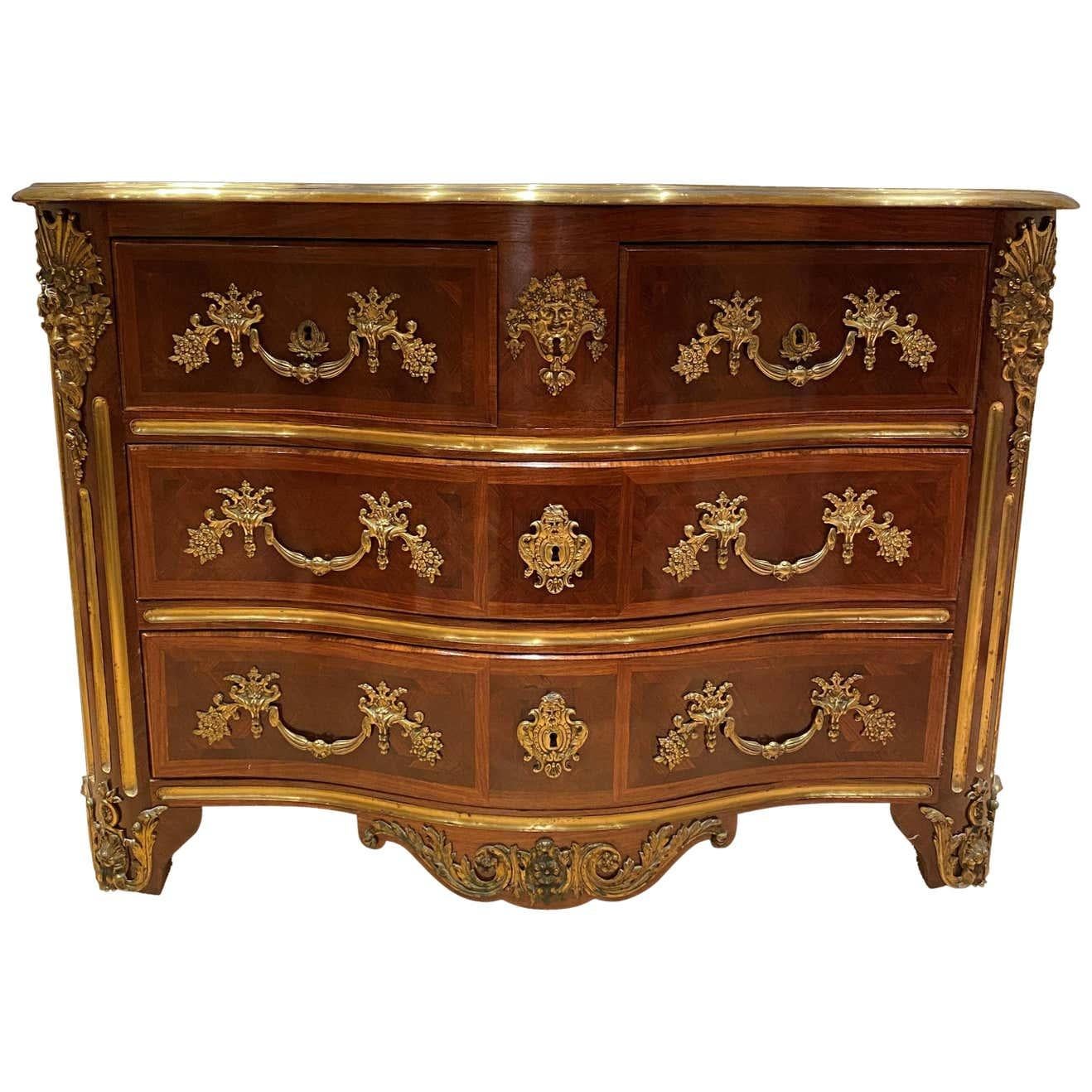 Una splendida commode francese del XIX secolo di Luigi XV St. a quattro cassetti in legno di re, tulipano e ormeggio. La commode a forma di bombe è sollevata su corte gambe cabriole decorate da maschere maschili in ormù che sovrastano montature a