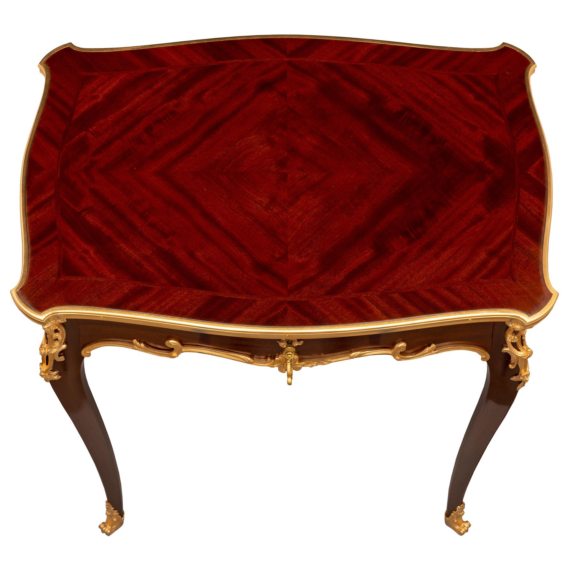 A splendid French 19th century Louis XV st. Mahogany and ormolu side table attributed to Sormani. The table is raised by elegant tapered cabriole legs with fine fitted foliate ormolu sabots and richly chased pierced corner mounts in a striking satin