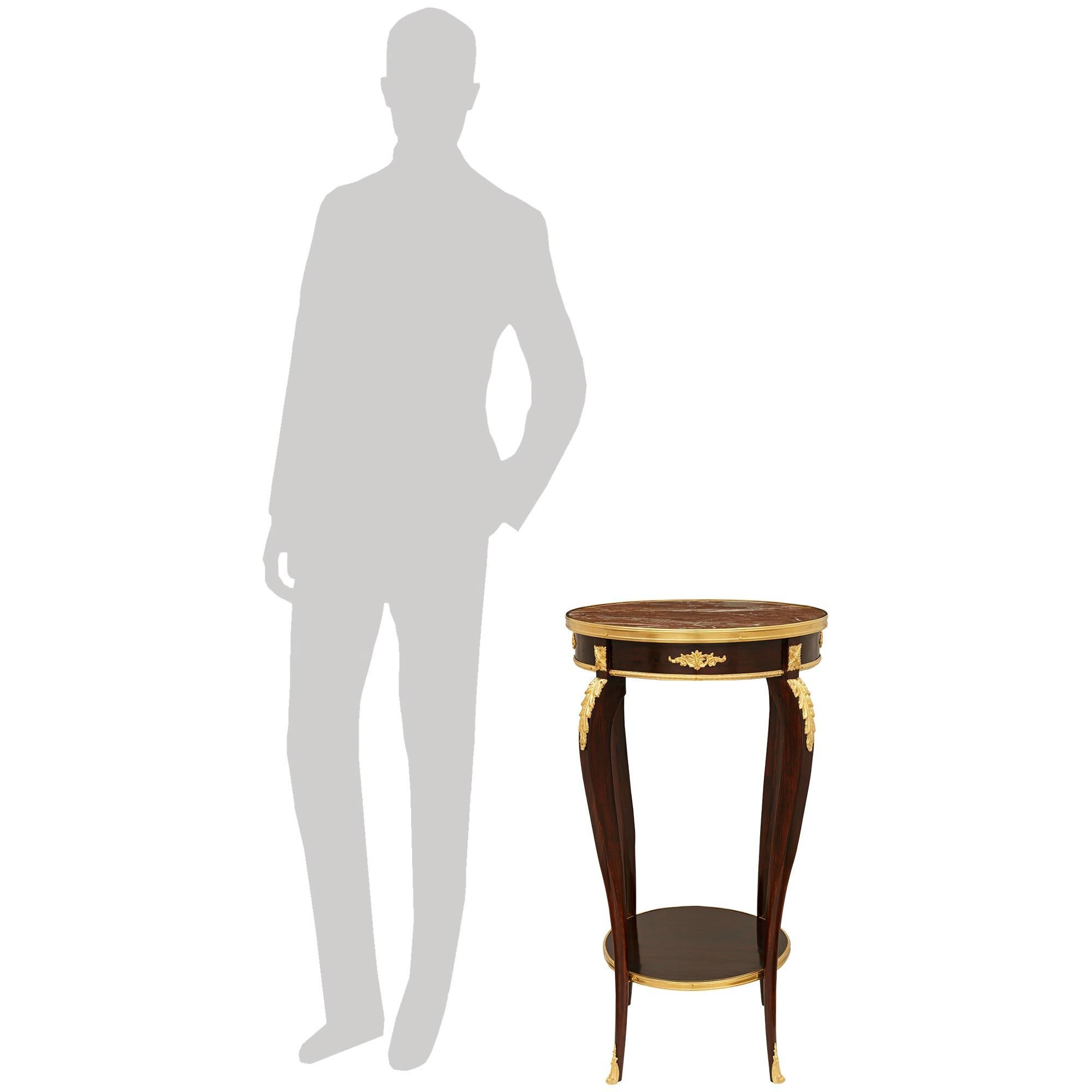 Elegante table d'appoint en acajou, marbre Rouge Royale et bronze doré de style Louis XV du XIXe siècle. Cette merveilleuse table circulaire repose sur de minces pieds cabriole effilés, avec de grandes montures de feuilles d'acanthe en bronze doré